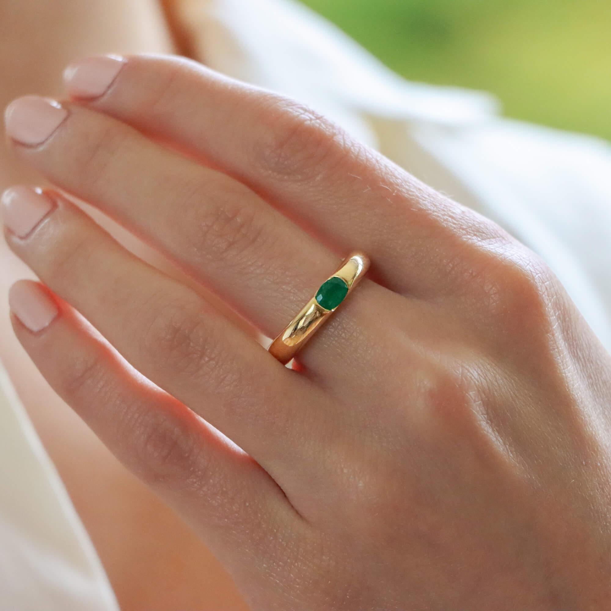 A beautiful vintage Cartier 'Ellipse' emerald band ring set in 18k yellow gold. 

From the now discontinued Ellipse collection, the ring is solely set with a vibrant oval cut green emerald. The emerald is securely bezel set within a 4-millimetre