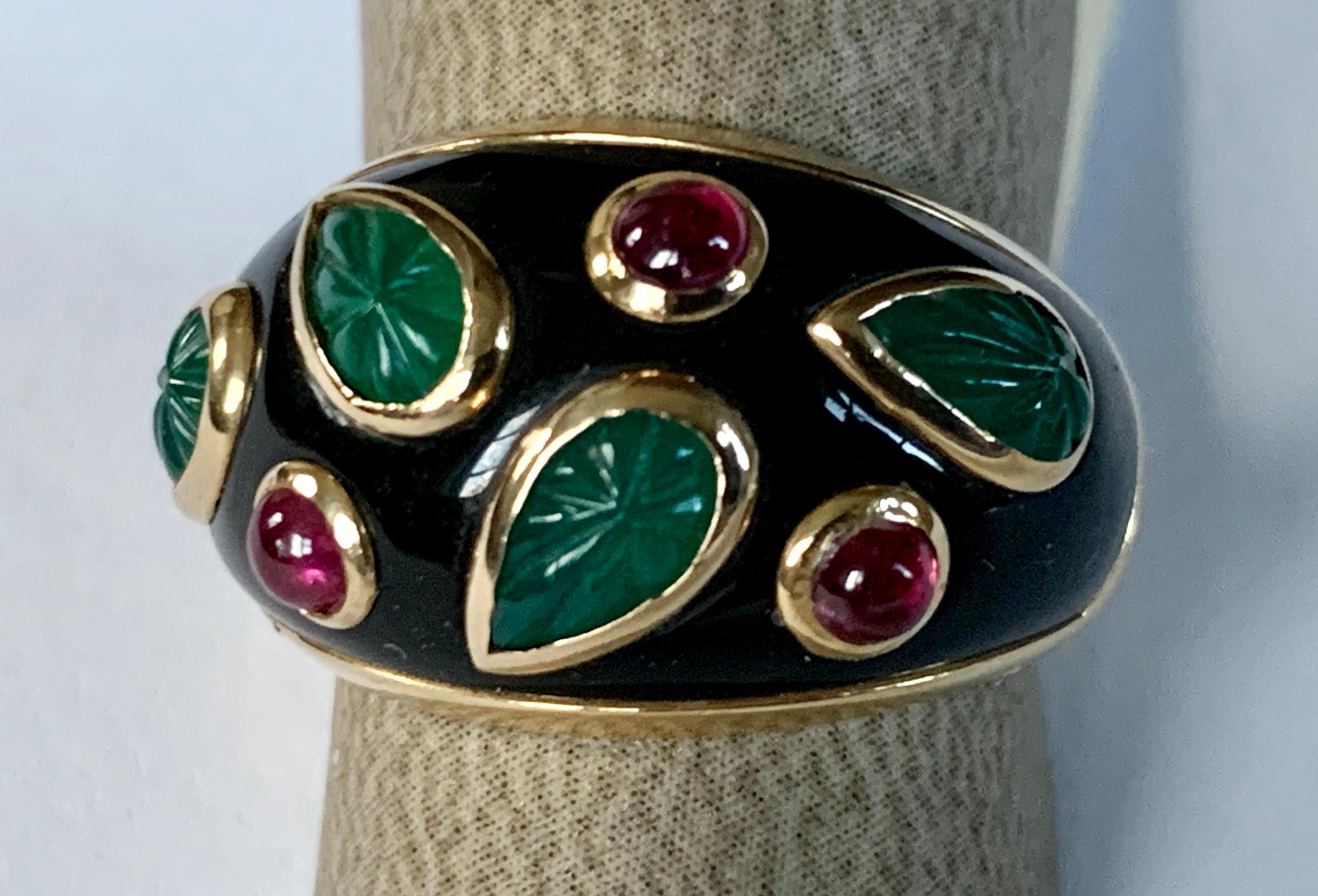A Cartier true work of art. 18 K yellow Gold ring set to the front with carved emerald leaves and round ruby cabochons. 
All bezel set on a field of black lacquer. 
Fully signed Cartier, stamped Cartier, 1991l numbered 928 747 , 49, 750 for 18 karat