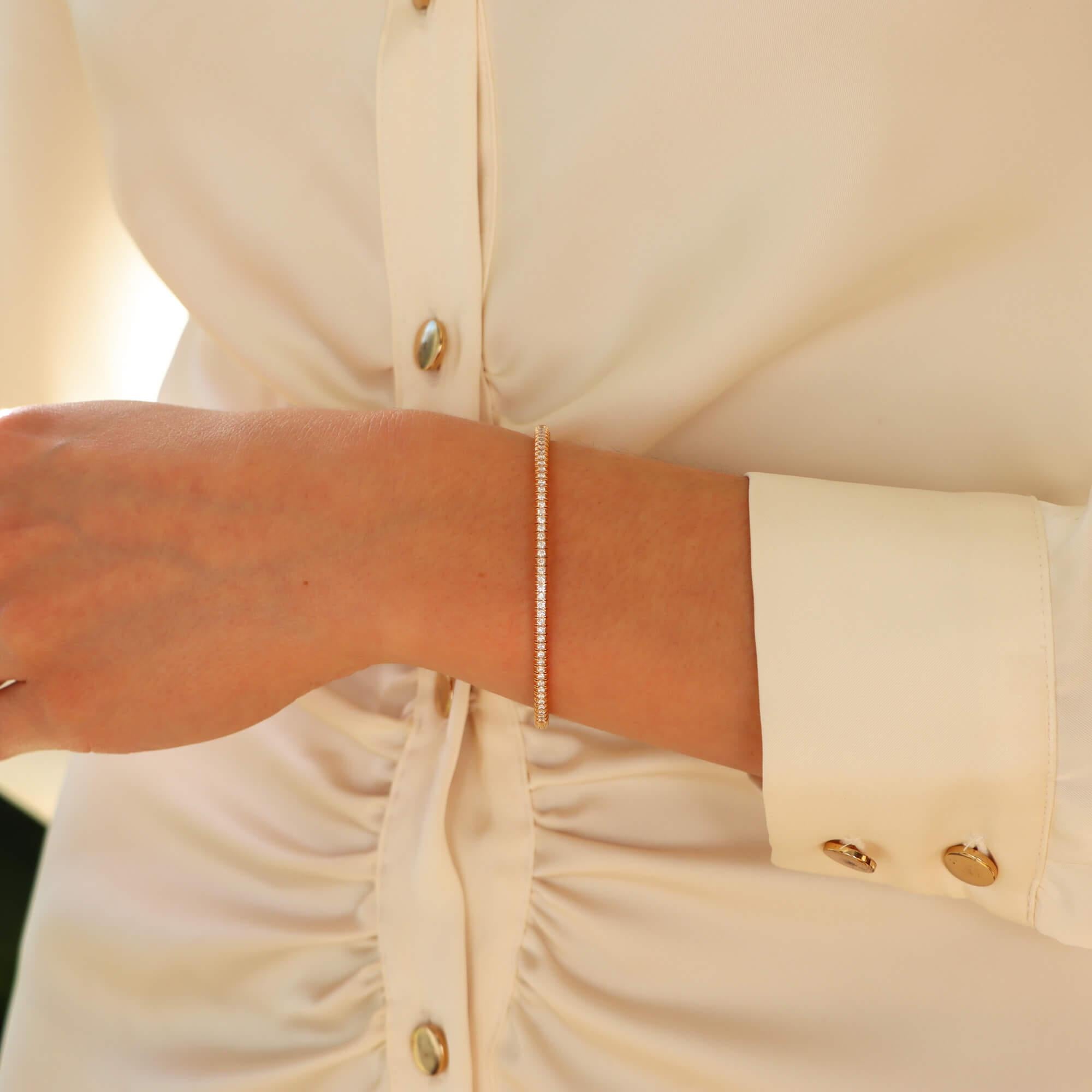 Un bracelet à charnière classique en or rose 18 carats de Cartier 'Etincelle'.

La pièce est composée d'un solide bracelet de 3 millimètres qui s'articule d'un côté avec un système de fermeture par clic et un dispositif de sécurité. L'un des côtés