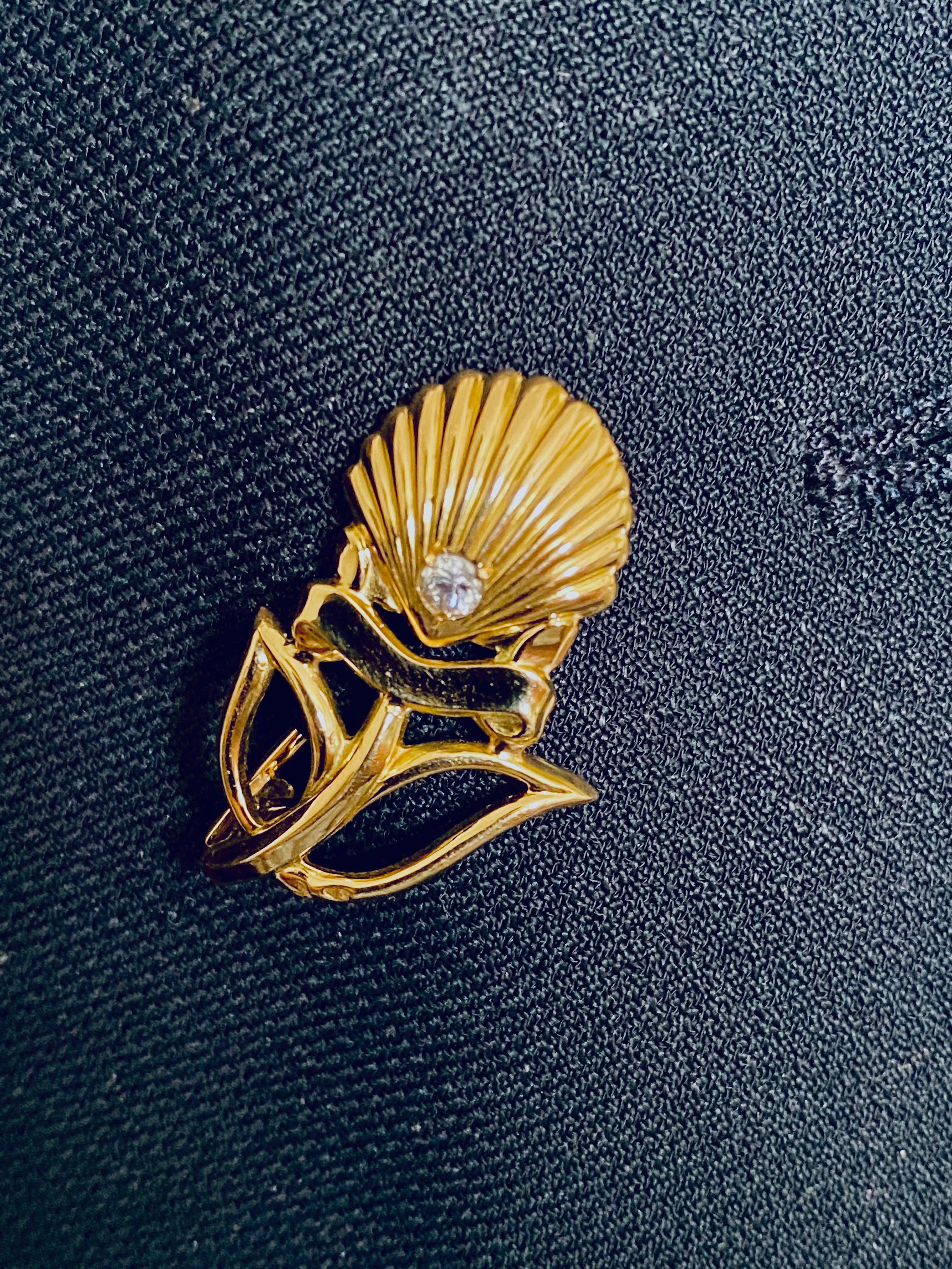 Vintage Cartier Brooch in 18 karat yellow gold, in the shape of a shell, studded with a diamond.
Maker's mark.
The brooch is in its own Cartier box
In excellent condition 
Brooch measuring 1.10 inch by 0.65 inch
According to the magazine Watch Time,