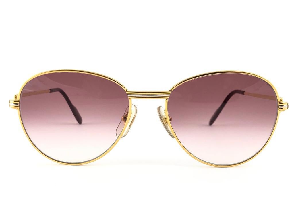 
In Excellent condition Cartier Louis Diamonds rounded sunglasses with 2 real diamonds on the side of the frame. Mauve gradient (uv protection) lenses. Frame is with the famous yellow and white gold accents on the front and on both sides. All