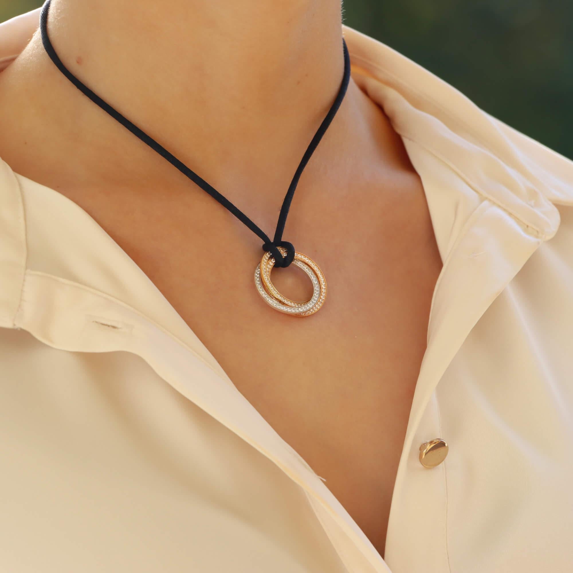 Eine schöne Vintage Cartier Trinity Diamanten Anhänger Halskette in 18k Rose, Gelb-und Weißgold gesetzt.

Das Collier aus der aktuellen Cartier Trinity-Kollektion zeichnet sich durch drei ineinander verschlungene Ringe aus Rosé-, Gelb- und Weißgold