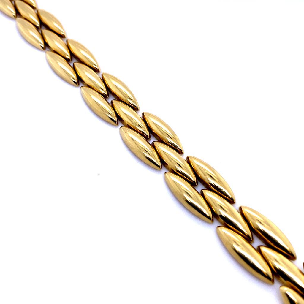 Cartier-Gentiane-Armband aus 18 Karat Gelbgold, um 1990

Dieses elegante Armband im Retro-Stil besteht aus drei Reihen, wobei jedes Segment die Form einer länglichen Raute hat. Es ist aus 18-karätigem Gelbgold gefertigt, fein poliert und mit einer