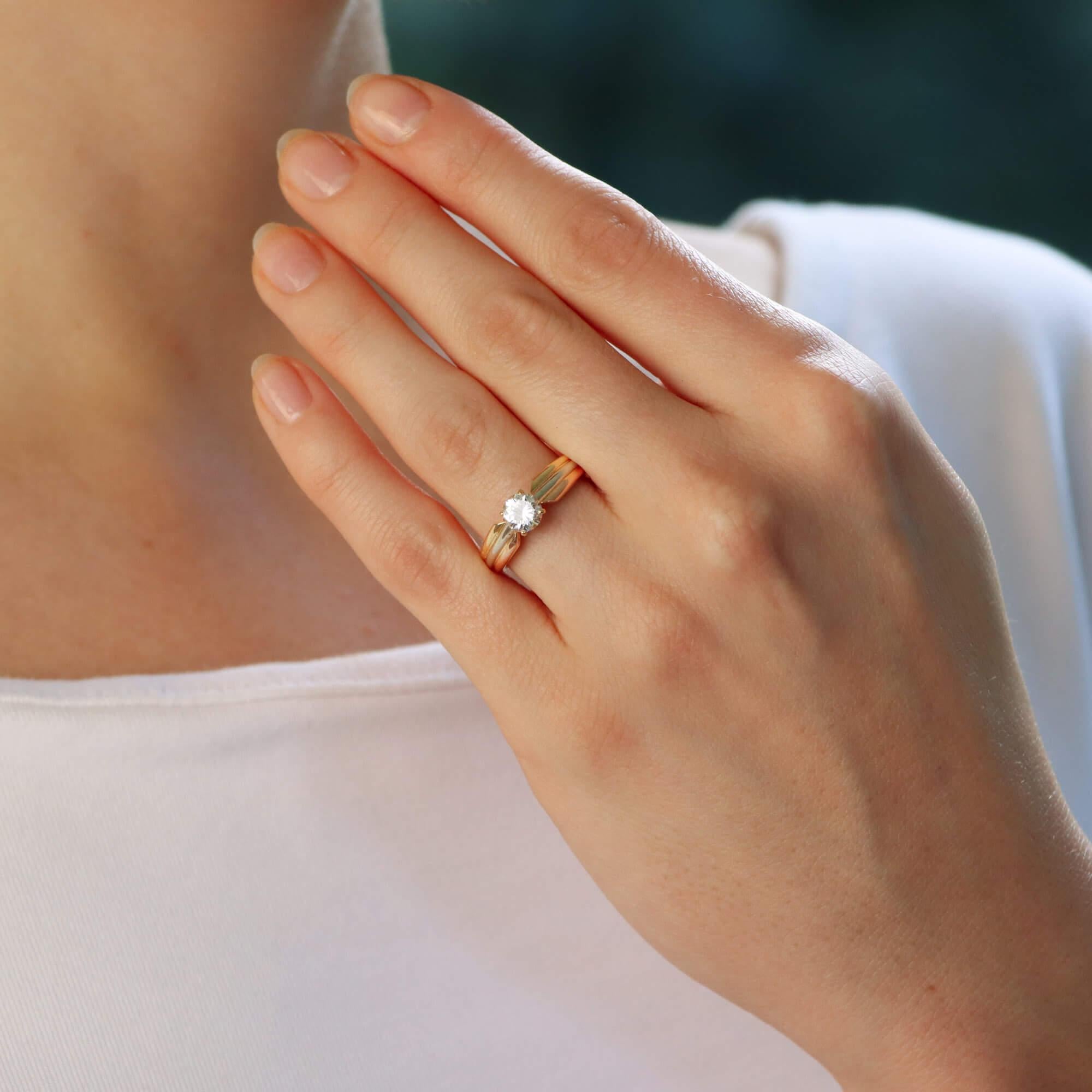 A beautiful vintage Cartier diamond solitaire trinity ring set in 18k yellow, white and rose gold.

The ring is centrally set with a GIA-certified round brilliant-cut diamond, which is securely claw set. The stone is set in a slightly raised open