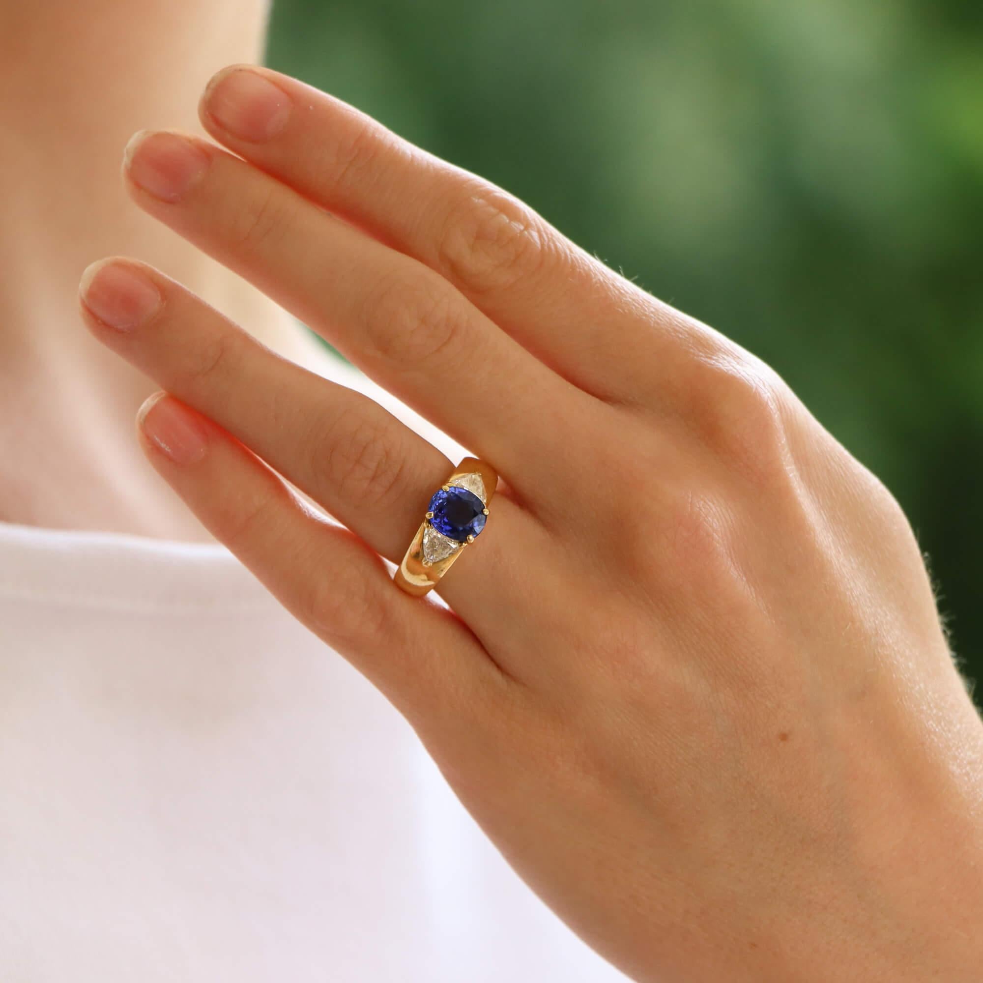 A truly stunning vintage Cartier GIA certified sapphire and diamond three stone ring set in 18k yellow gold.

The ring is centrally set with a beautiful 2.56ct oval cut sapphire which is four claw set in an elegant open back yellow gold setting. To