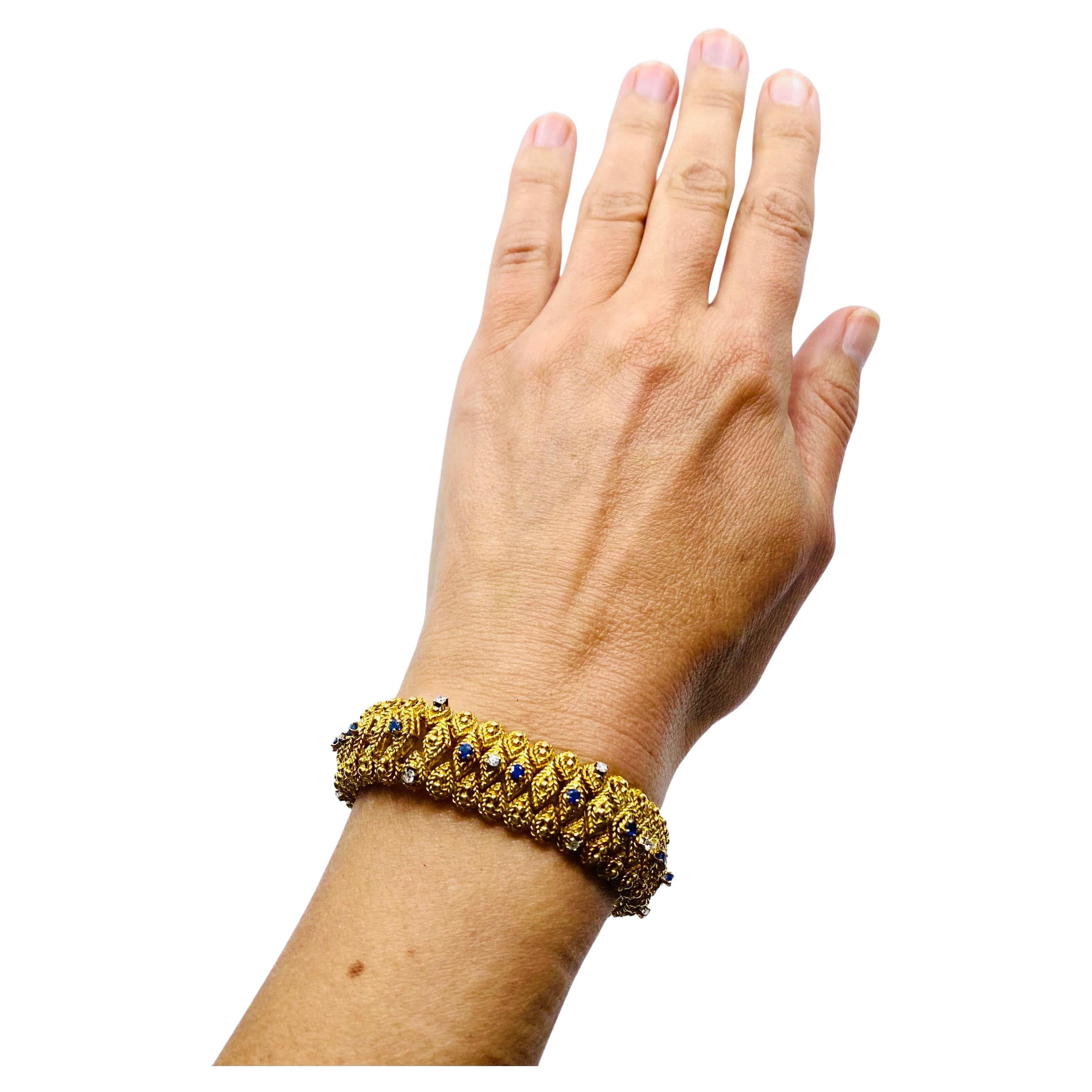 A gorgeous vintage Cartier bracelet made of 18k gold, featuring sapphires and diamonds. The bracelet of intricate design comprises tiny sections flexibly connected to each other. The center is consisted of the rhombus shape sections, and the outer