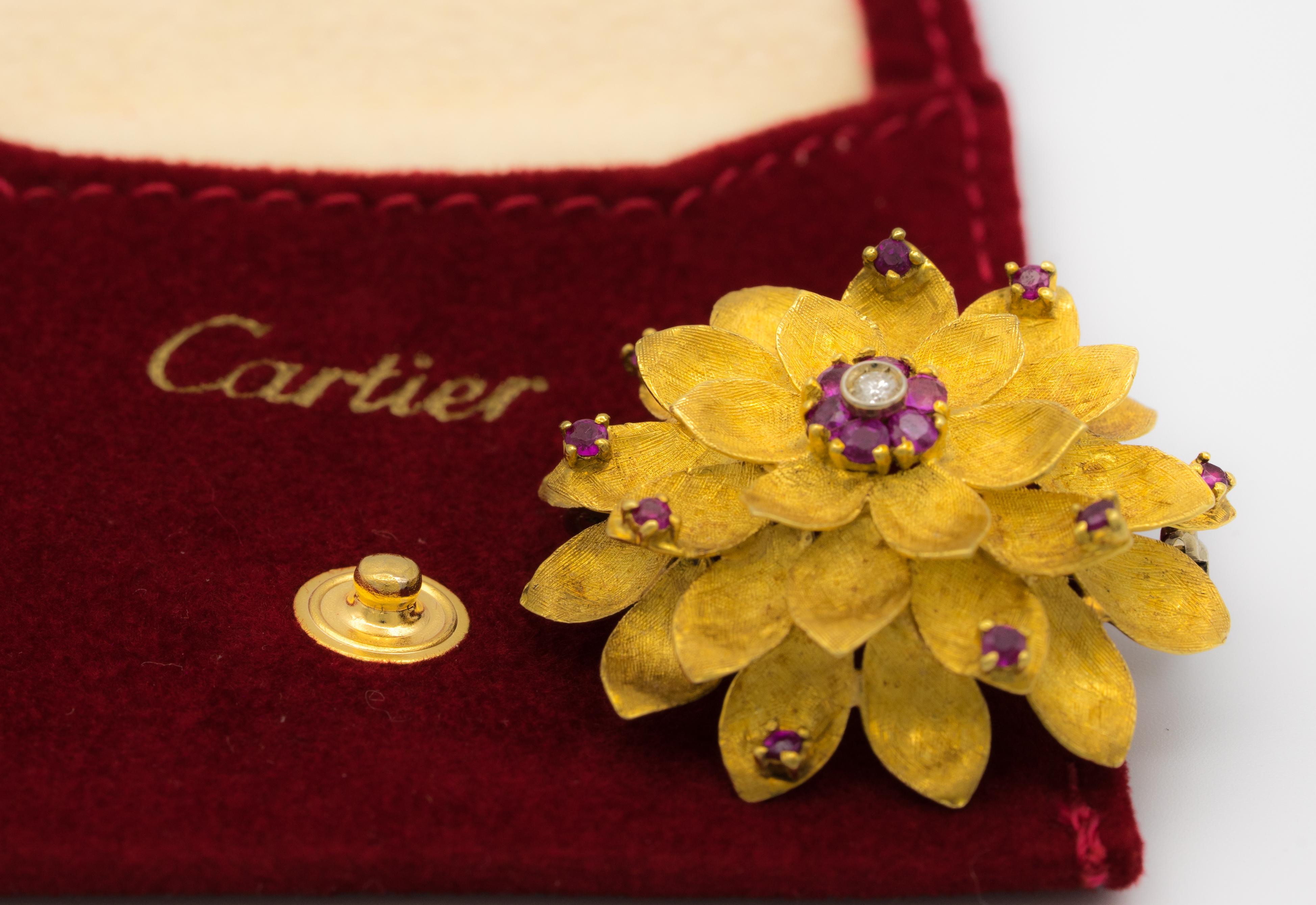 Vintage Cartier Gold, Ruby and Diamond Flower Brooch Circa 1950's in 18 kt gold.
Delicate textured leaves , 15 rubies and a diamond center create this exquisite graceful and gentle vintage Brooch from Cartier.  

Designer: Cartier 
Hallmarks: