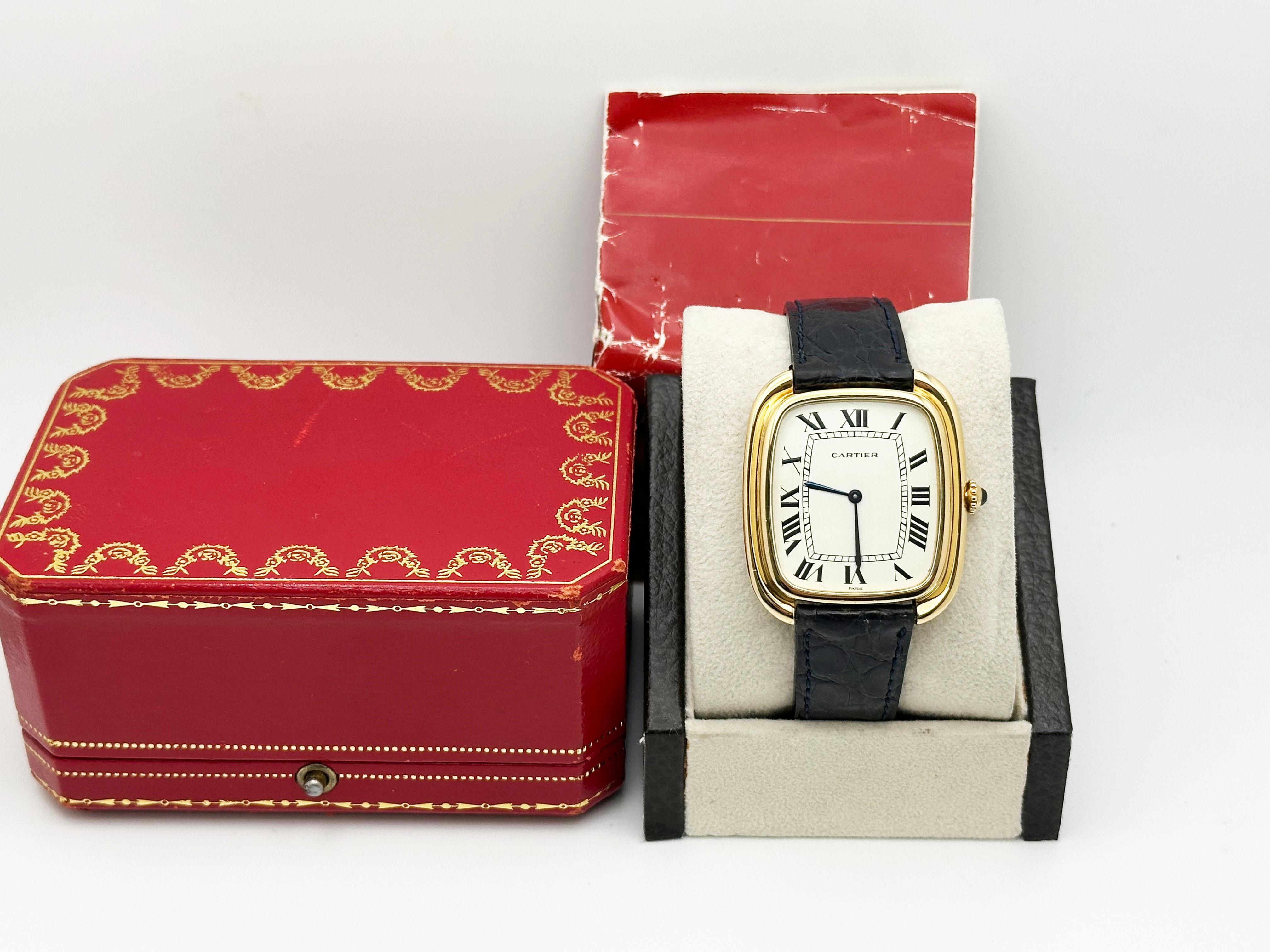 Stilnummer: 97050

Jahr: 1970er Jahre
 
Modell: Cartier Jumbo Gondole
 
MATERIAL des Gehäuses: 18K Gelbgold 
 
Band: Lederarmband 
 
Lünette: 18K Gelbgold 
 
Wählen:  Weiß 
 
Gesicht: Saphirglas 
 
Gehäusegröße: 34mm x 39mm
 
Enthält: 
-Cartier Box