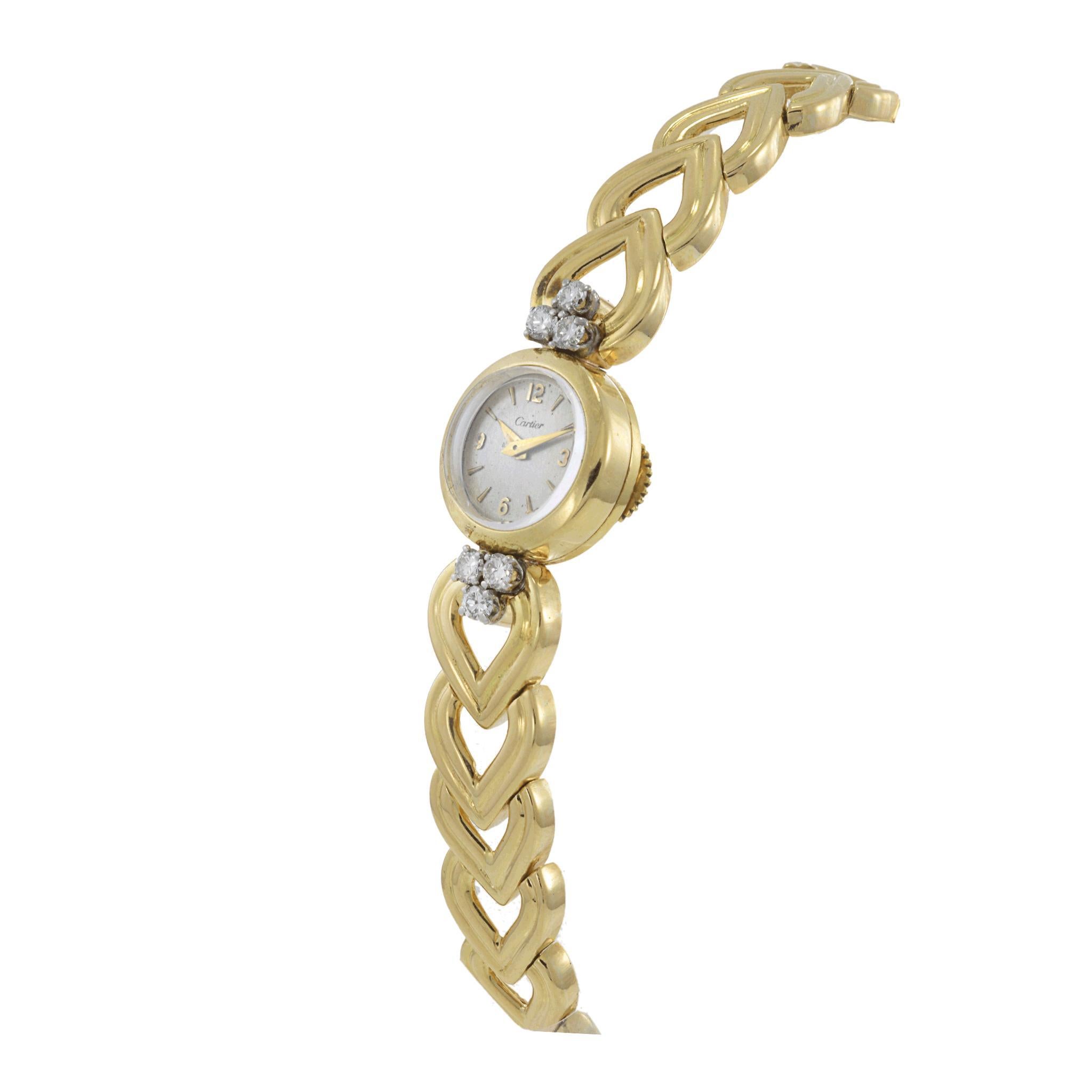 Exquisito reloj de cóctel Cartier de época para señora, con diamantes, fabricado en oro amarillo de 18 quilates con brazalete cónico en forma de corazón, elegantemente firmado Cartier S.A., Made in France 18Kts. La esfera plateada presenta números