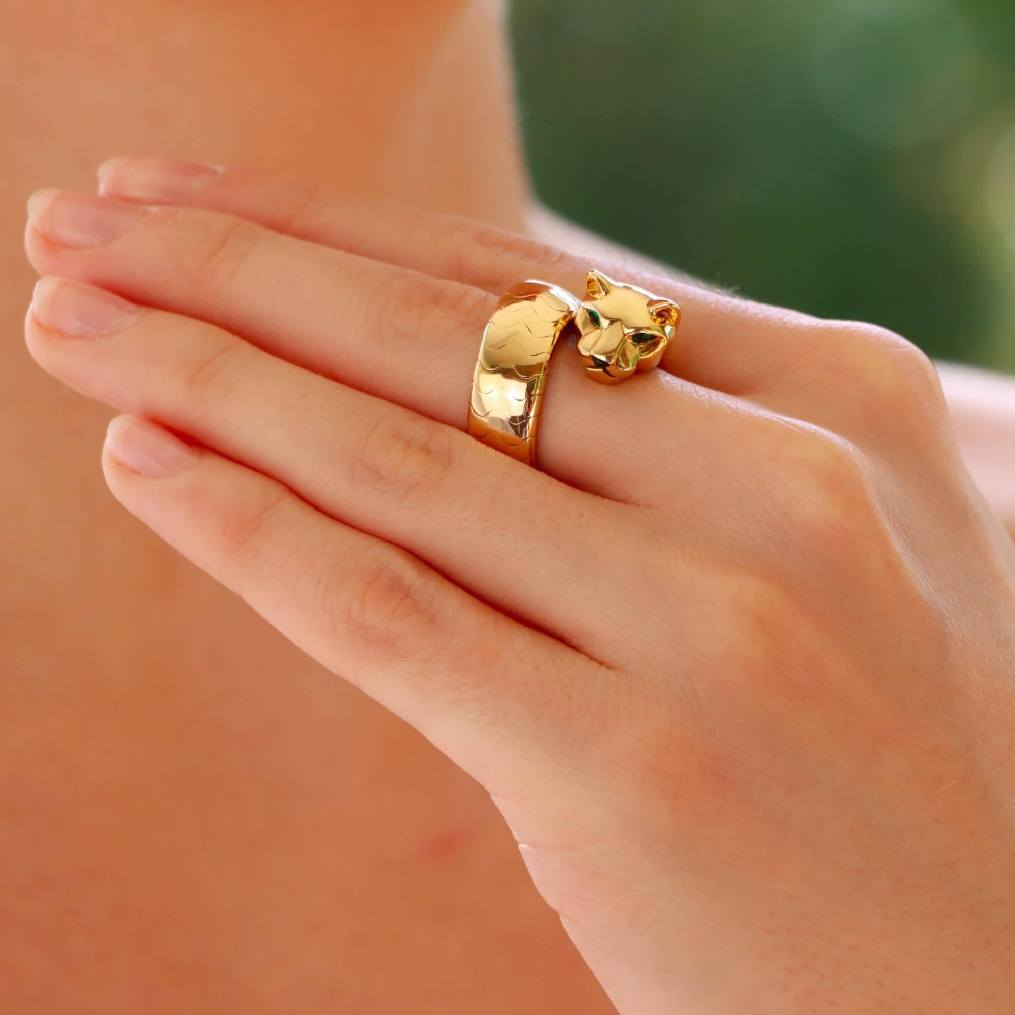 A stylish vintage Cartier Lakarda panther ring set in 18k yellow gold.

In the brand’s iconic panther motif, this ring depicts a panther head, which flows through to a slightly articulated thick spring band. The panther has been beautifully crafted