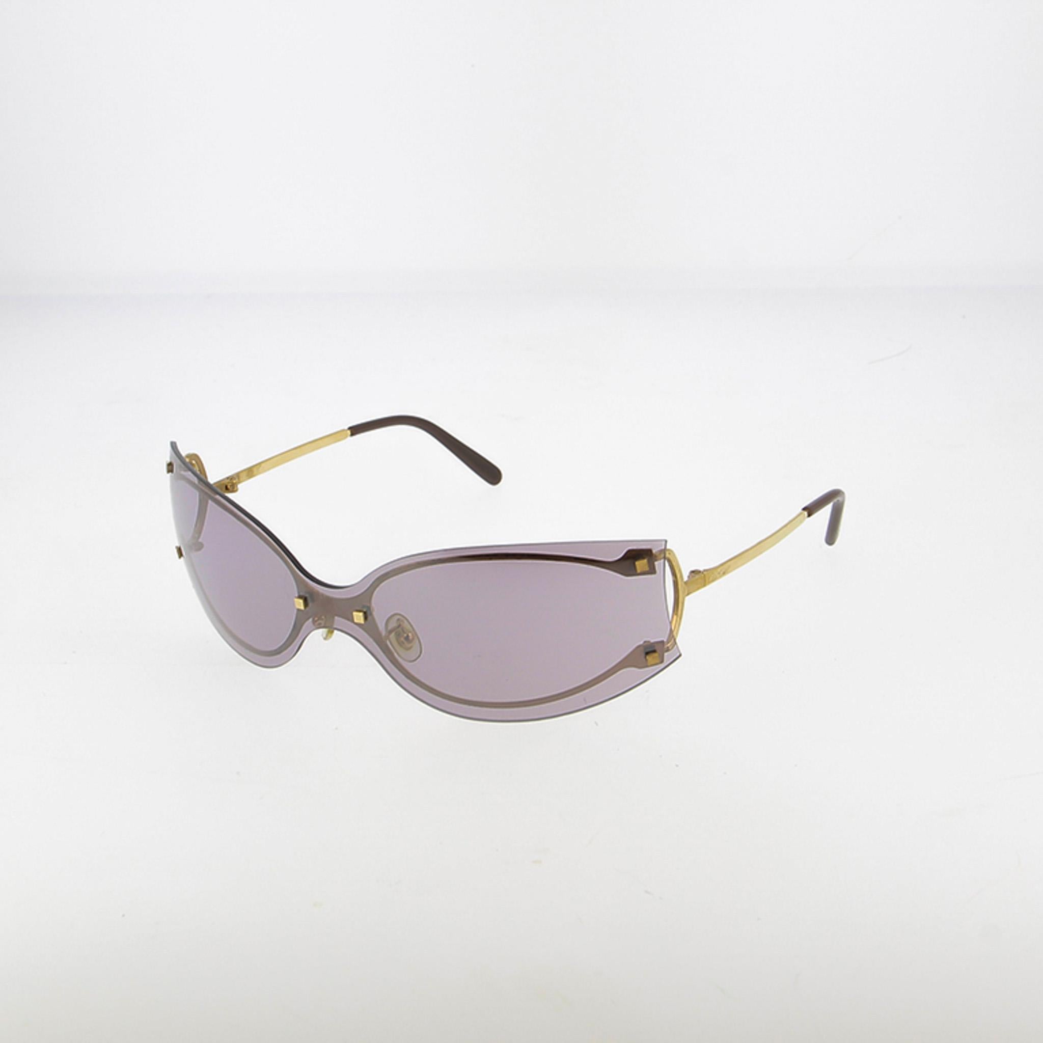 Scopri questi magnifici occhiali da sole a mascherina di Cartier, una creazione audace che combina perfettamente lo spirito sportivo degli anni 2000 con l'eccezionale maestria artigianale della Maison francese di gioielli. Un'autentica dichiarazione