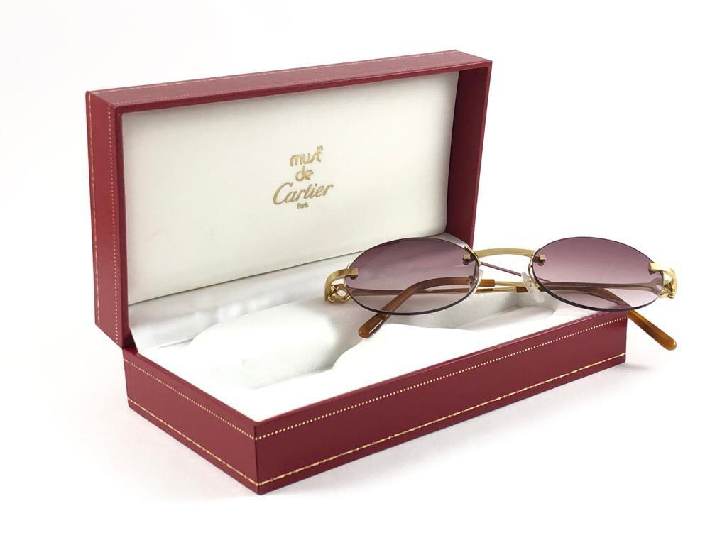 1990 Cartier gold plated unique rimless sunglasses with light rose gradient  (uv protection) lenses. 
Frame with the front and sides in gold. All hallmarks. 

Cartier signs on the tortoise ear paddles. 

Please notice this item its nearly 30 years