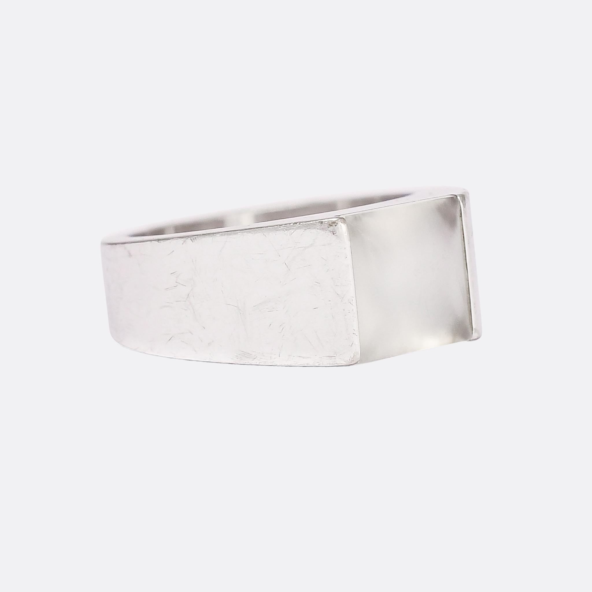 A cool vintage Cartier signet ring dating from the 1990s. The head is set with an unusually cut white moonstone, square in shape, with a shallow cabochon top and four pavilion facets underneath. It's beautifully made, crafted in 18 karat white gold
