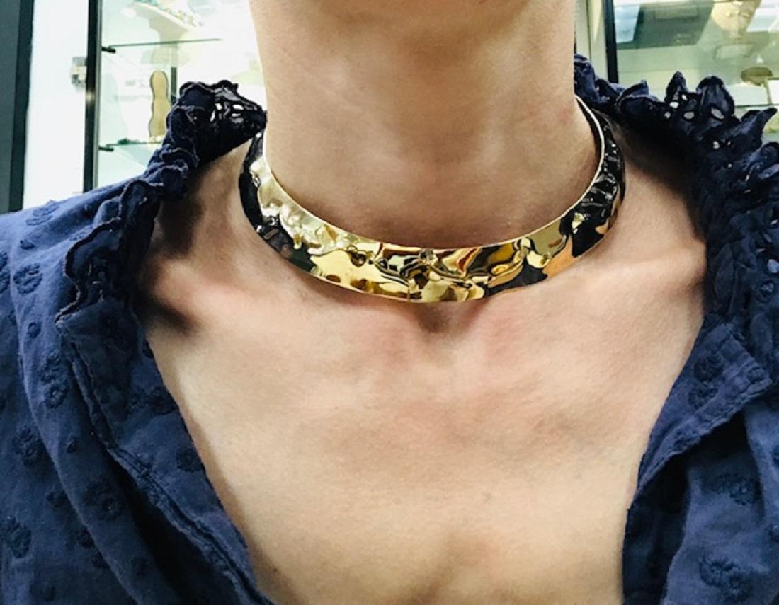 A shiny vintage Cartier necklace, made of 18k hammered gold.
The necklace of choker design is minimalistic yet luxurious. Its wrinkled, high-polished gold surface is glossy and textured at the same time. A hidden hook allows to hang a pendant and