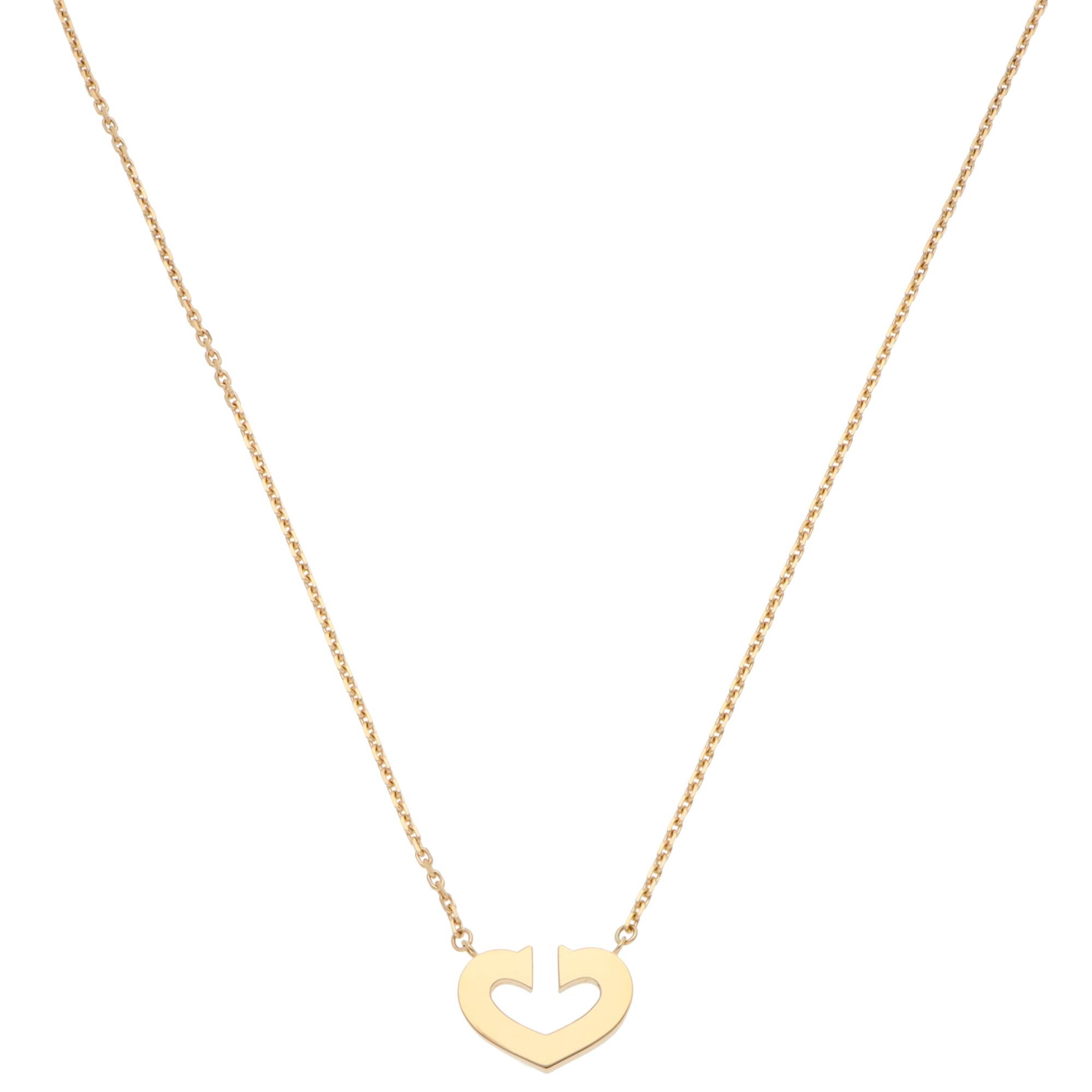 A beautiful vintage C de Cartier double C heart necklace set in 18k yellow gold.

The necklace solely features the iconic double C heart motif. It is securely connected to a Cartier single-stranded trace chain. Due to the design and size, this piece