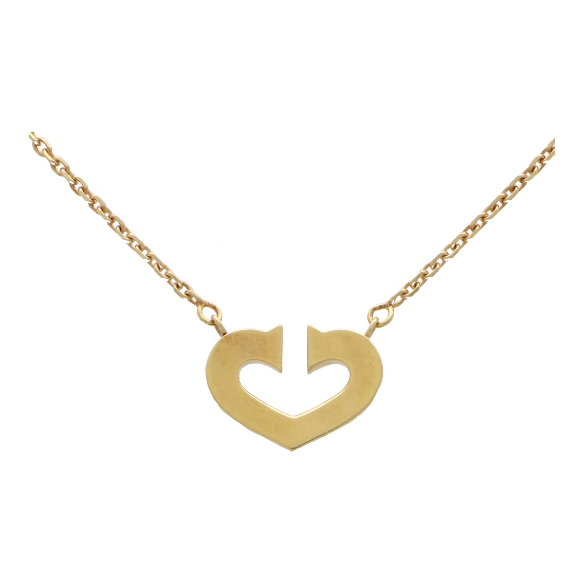 Magnifique pendentif en forme de cœur ouvert en double C de Cartier en or jaune 18 carats.

Le collier présente uniquement le motif emblématique du cœur en double C et est suspendu à une chaîne en or jaune fin. Le collier est solidement attaché à