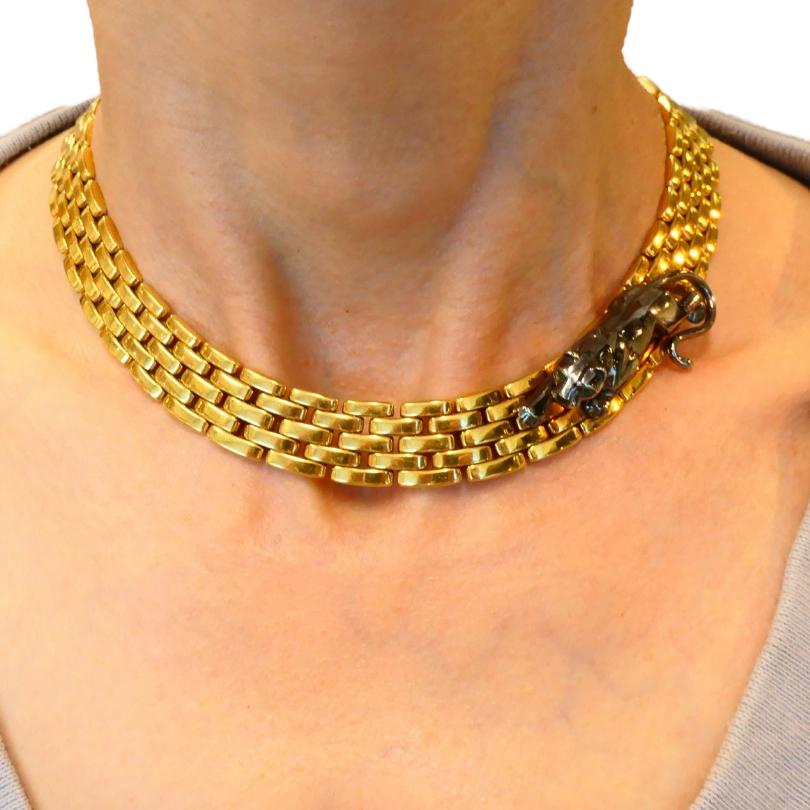 A striking vintage Cartier Panthere necklace made of 18k gold, featuring a panther.
This collar necklace designed as three rows of softly curved brick-link chains. Because of its low profile, the necklace’s surface beautifully catches light as the