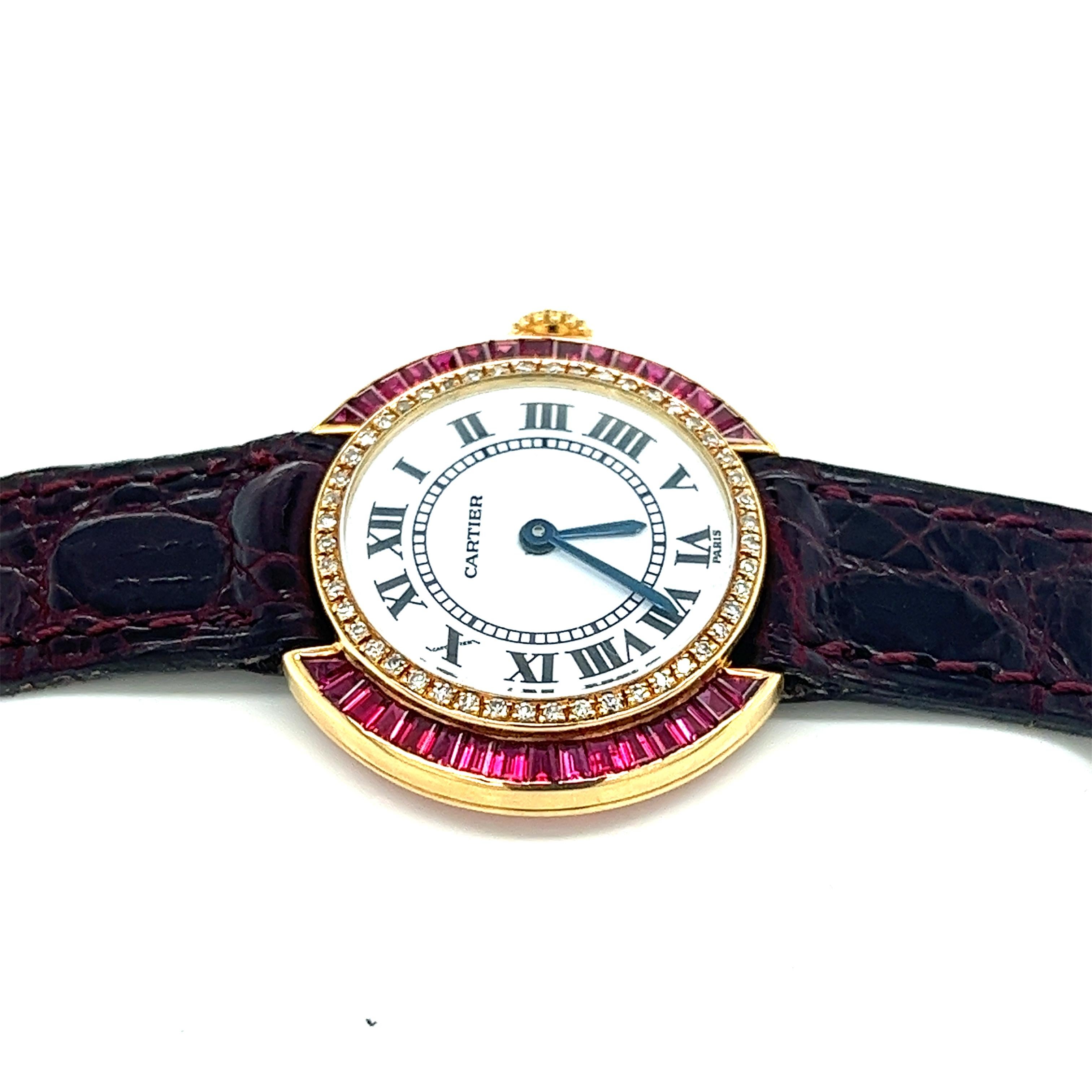Cartier Paris 18k yellow gold and red leather ladies wristwatch with baguette cut ruby and round cut diamond bezel. 28mm width round case with faceted crystal push/pull crown. 18K deployment clasp that fits 6.5 inch wrist (message for resizing).