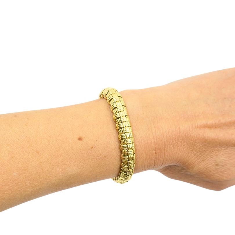 Dieses Vintage-Armband von Cartier Paris aus der Mitte des 20. Jahrhunderts besticht durch sein kühnes Retro-Gitterdesign aus 18 Karat Gold. Sie ist 7 1/2 Zoll lang und 5/16 Zoll breit und wiegt 49,8 Gramm. Sie ist mit französischen Punzen und dem