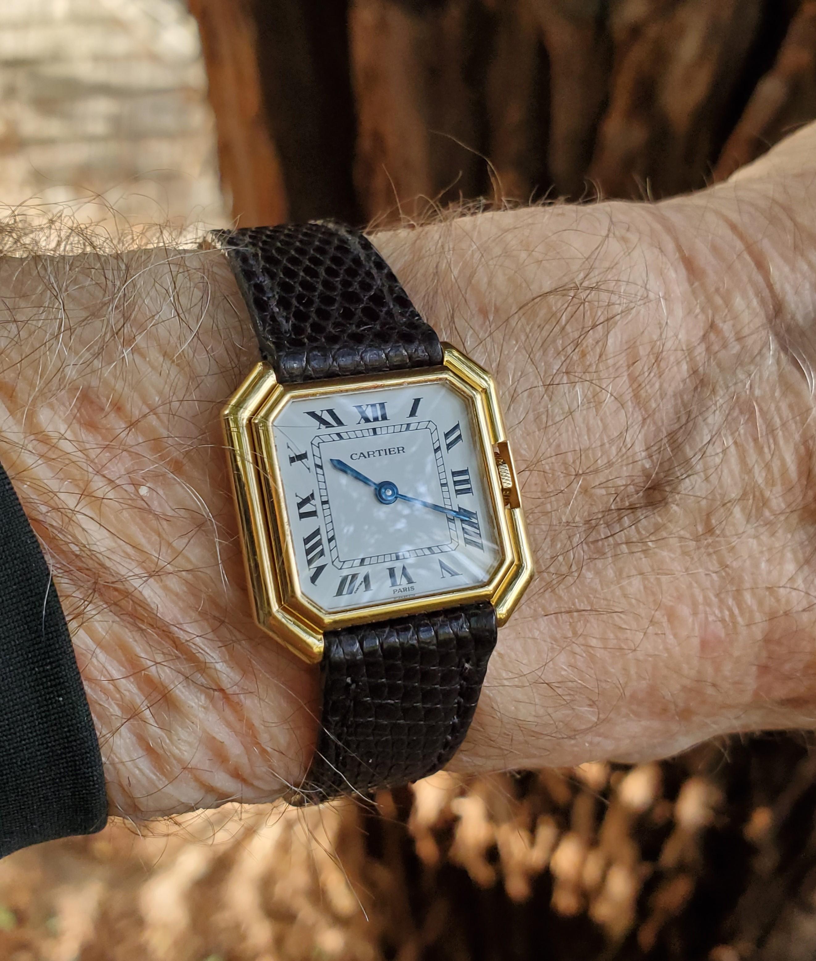 Introduction :
Cette montre Vintage Cartier Paris Ceinture Octagon Shape est de taille moyenne, et mesure 28 x 28mm.  La montre est réalisée en or jaune 18 carats avec un mouvement mécanique à remontage manuel à 17 rubis.  La montre a un cadran