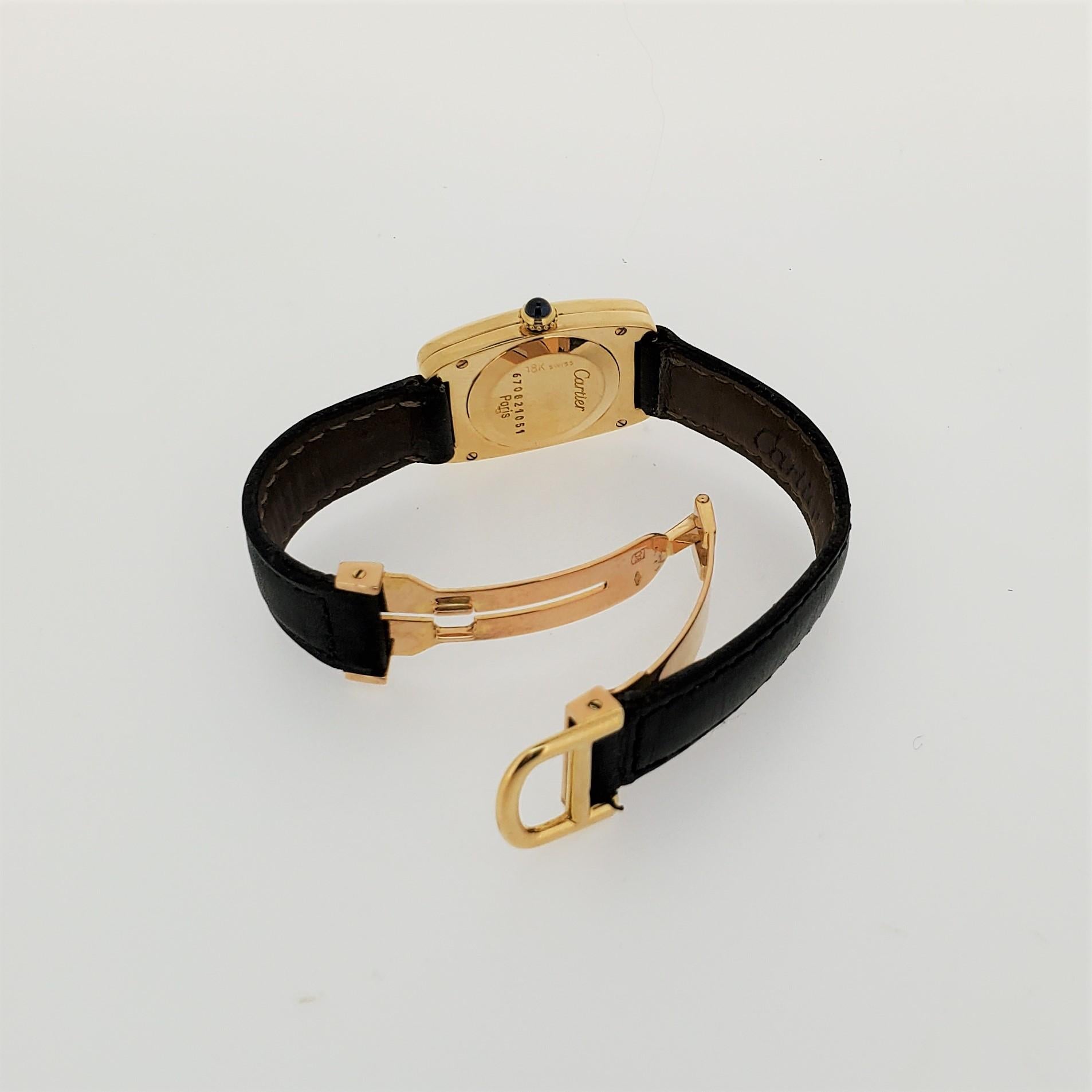 Introduction:
Cartier Faberge' Tonneau watch, made in 18K yellow gold, measuring 26 x 32 mm.  White dial, black roman numerals. signed movement, case, dial.  The watch is accompanied with an Cartier 18K yellow gold deployant buckle with Cartier