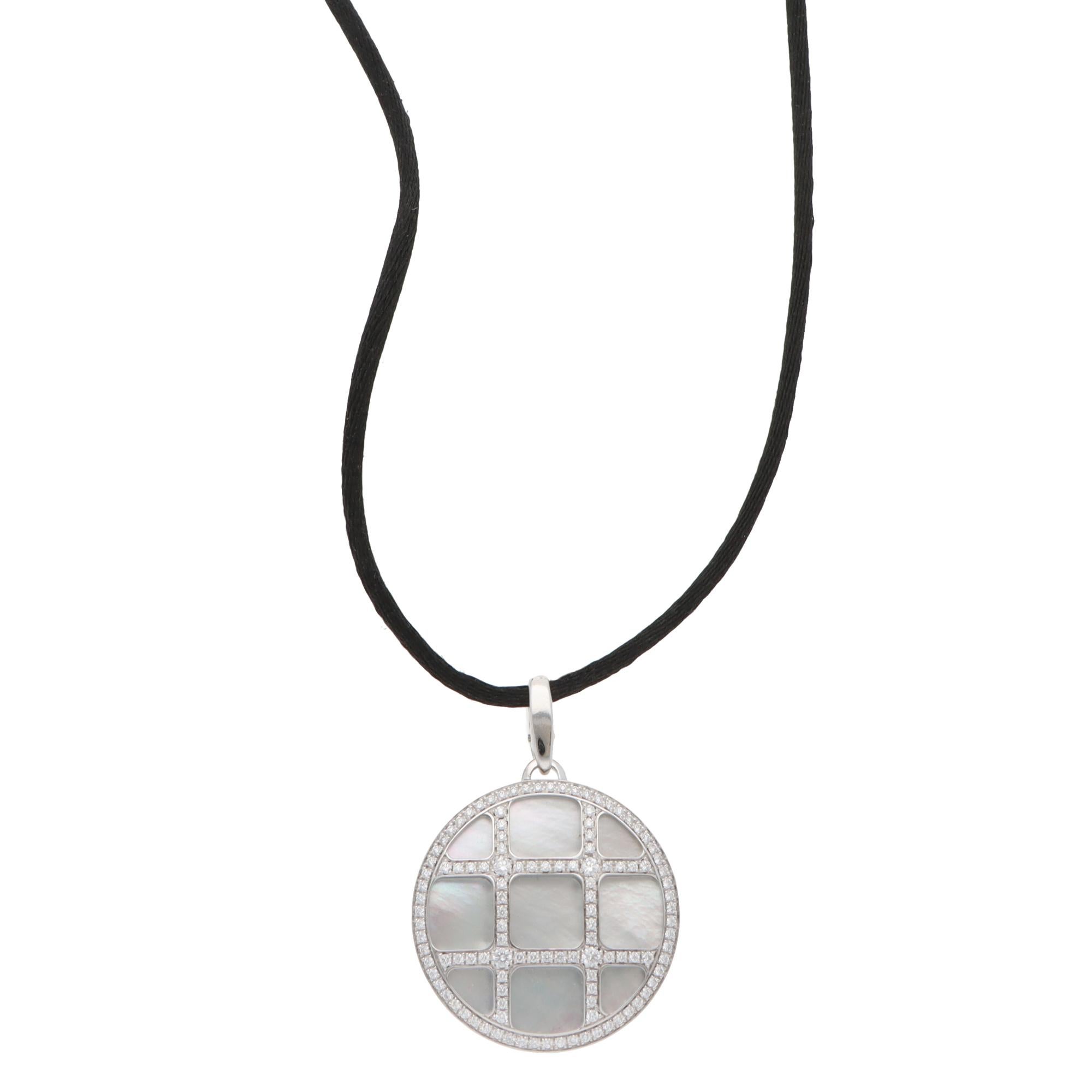 Una classica collana vintage Cartier Pasha con madreperla e diamanti incastonati in oro bianco 18 carati.

Della collezione Pasha, il ciondolo è incastonato con uno sfondo di madreperla bianco-argentea e oltre 100 diamanti rotondi a taglio brillante