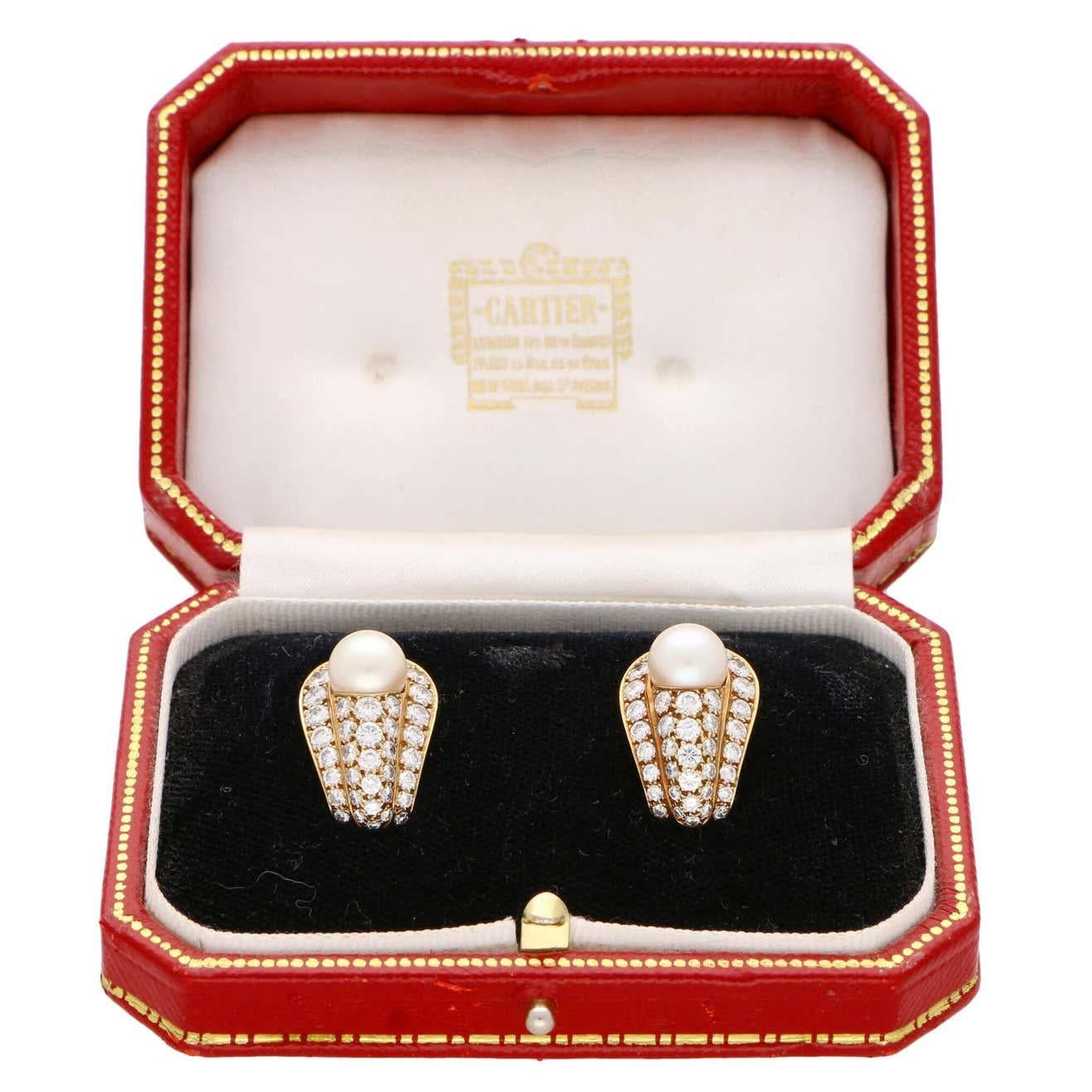 A truly beautiful pair of vintage Cartier pearl and diamond earrings set in 18k yellow gold.

Each earring is centrally set with a beautiful lustrous 8-8.5 millimetre cream colored pearl. These pearls are each set within a cluster formed of 37 round