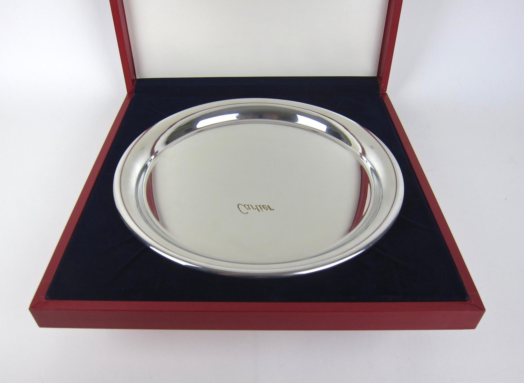 A vintage Cartier silver serving tray in highly polished and reflective pewter, made in France, circa 1977. The round tray has a sleek Minimalist design with a wire-wrapped rim and is stamped 