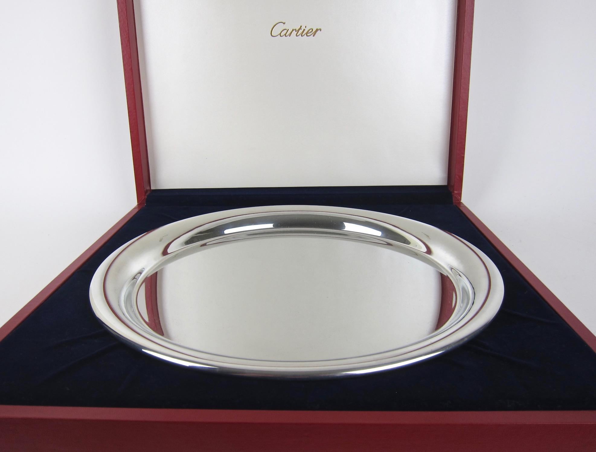 An elegant vintage Cartier serving tray in highly polished pewter, made in France, circa 1977. The round tray has a modern, Minimalist design with a wire-wrapped rim; stamped 
