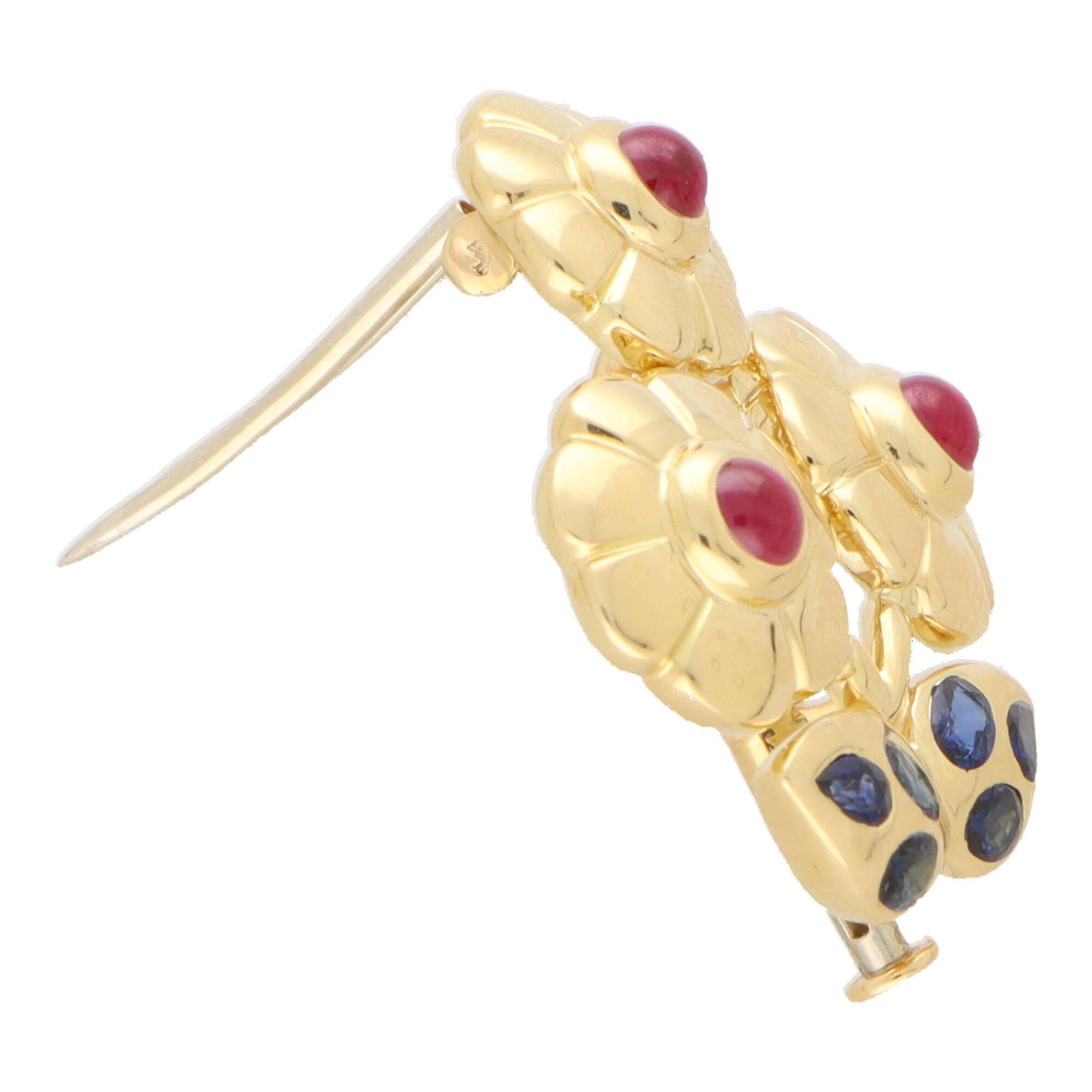 A beautiful vintage Cartier blue sapphire and ruby flower brooch set in 18k yellow gold.

The brooch depicts a beautiful flower display and secured to reverse with a double pin fitting. Each flower is set to the centre with a vibrant cabochon ruby
