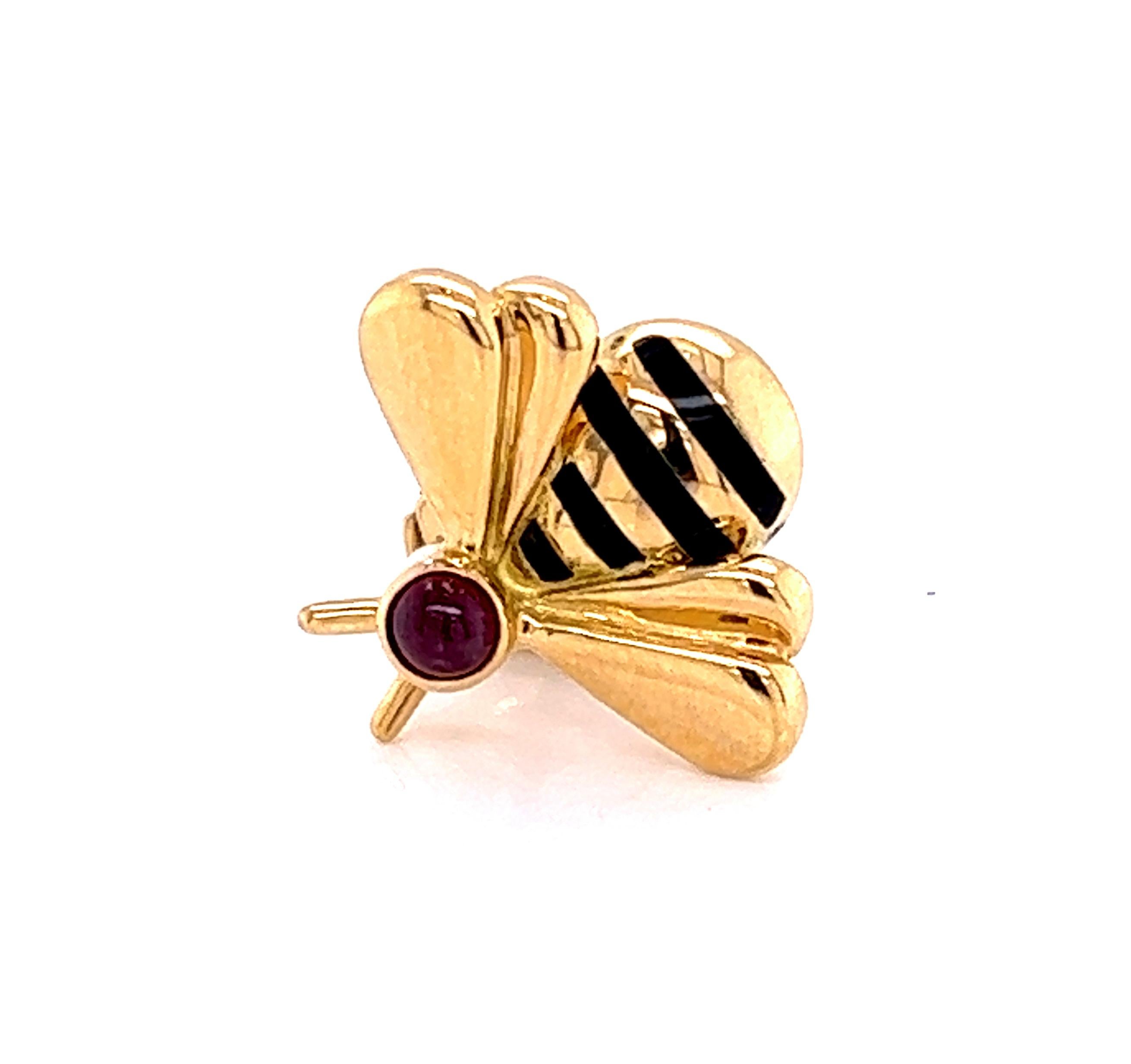 This adorable authentic tack pin is by Cartier, it is crafted from 18k yellow gold featuring a cute bumble bee with a cabochon ruby on the head and black enamel stripes with gold on the body with polished double wings. The pin comes with a post and