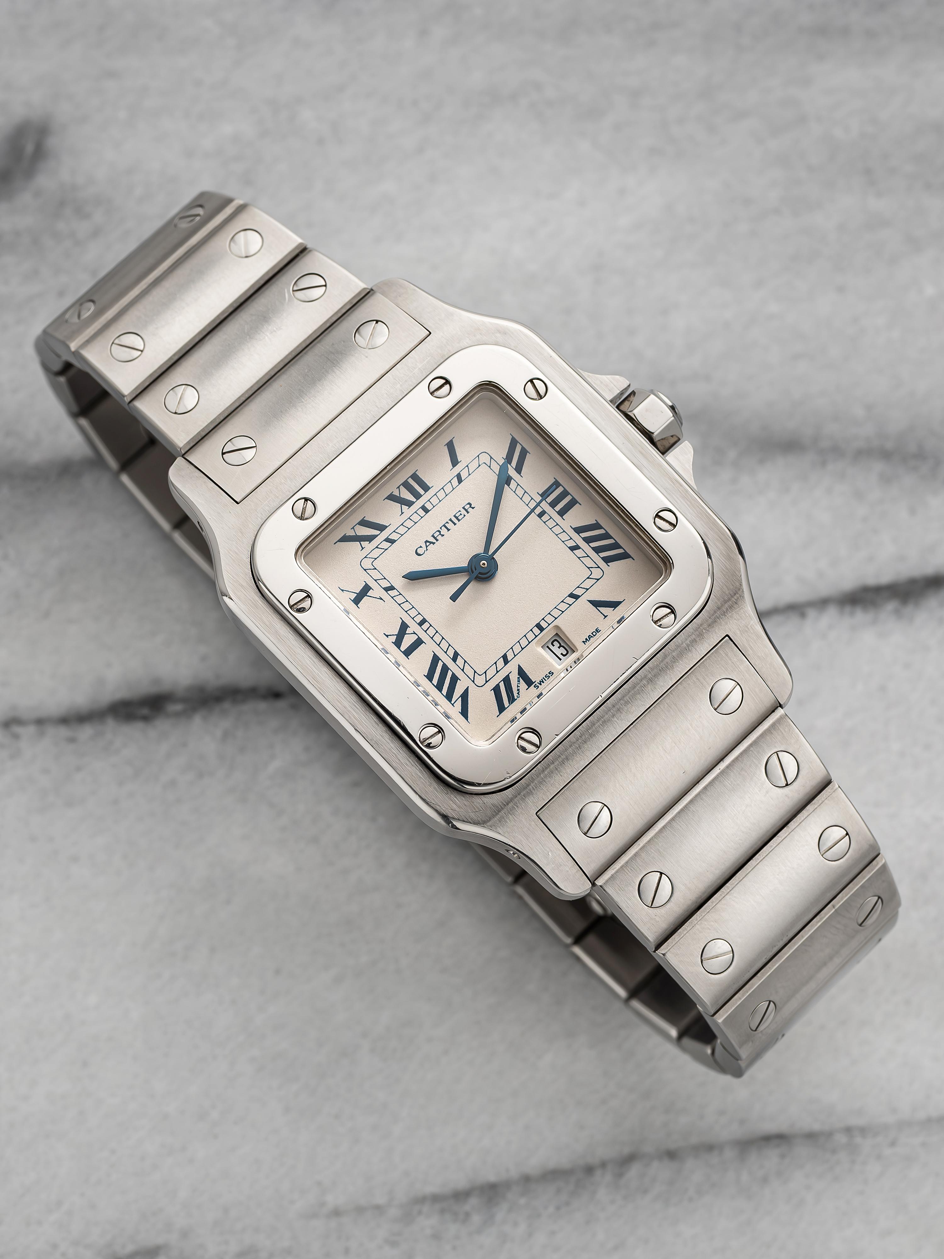 Here's a vintage Cartier Santos Galbee reference 1564 quartz with a white blue Roman numeral dial from the late 80s, early 90s. Keeps great time and is fully functional. Measurements include a 29x41mm square case size and 18mm lug width. Integrated