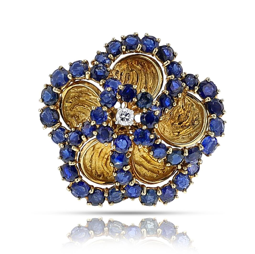 A Vintage Cartier Sapphire and Diamond Floral Pendant Brooch and Earring Set made in 18 karat yellow gold. The sapphires weigh a total of appx. 20 carats and the diamonds weigh appx. 0.45 carats. Signed and numbered. The total weight is Total weight