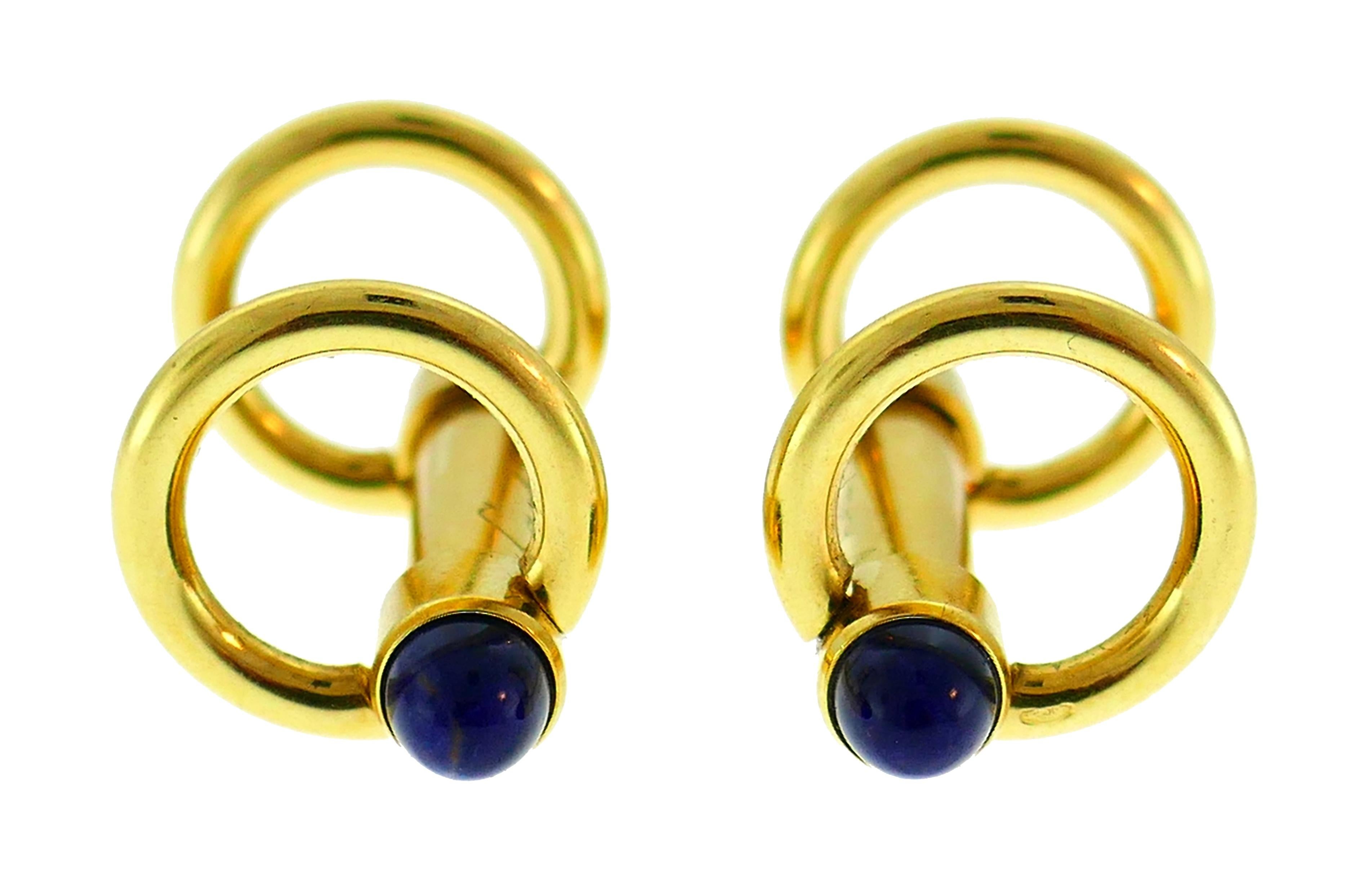 Classy cufflinks created by Cartier in France. 
Made of 18 karat (stamped) yellow gold and sapphire cabochons. 
Measurements: 1-1/2 x 1/2 inch (3.7 x 1.3 cm), the bars 1 x 1/8 inch (1.6 x 0.4 cm). 
Weight 11.5 grams.
Stamped with Cartier maker's
