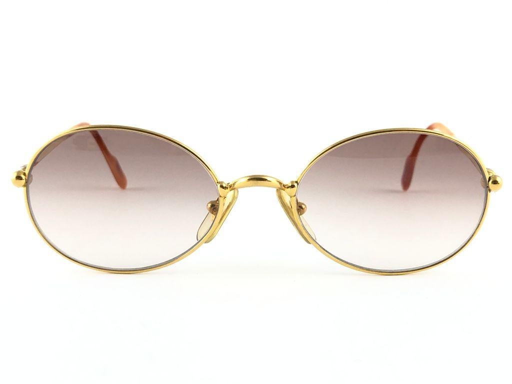 1990 Cartier Saturne Sunglasses with brown gradient  (uv protection) lenses. All hallmarks. Cartier gold signs on the ear paddles. 
These are like a pair of jewels on your nose. 
Please notice this pair is nearly 30 years old and may have minor sign