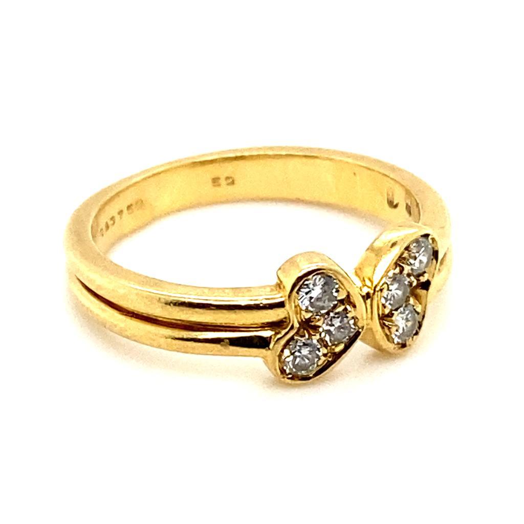 A vintage Cartier six stone diamond love heart ring in 18 karat yellow gold.

The ring is designed as a pair of love hearts; each of which has been grain set with a trio of round brilliant cut diamonds leading onto a plain polished split 18 karat