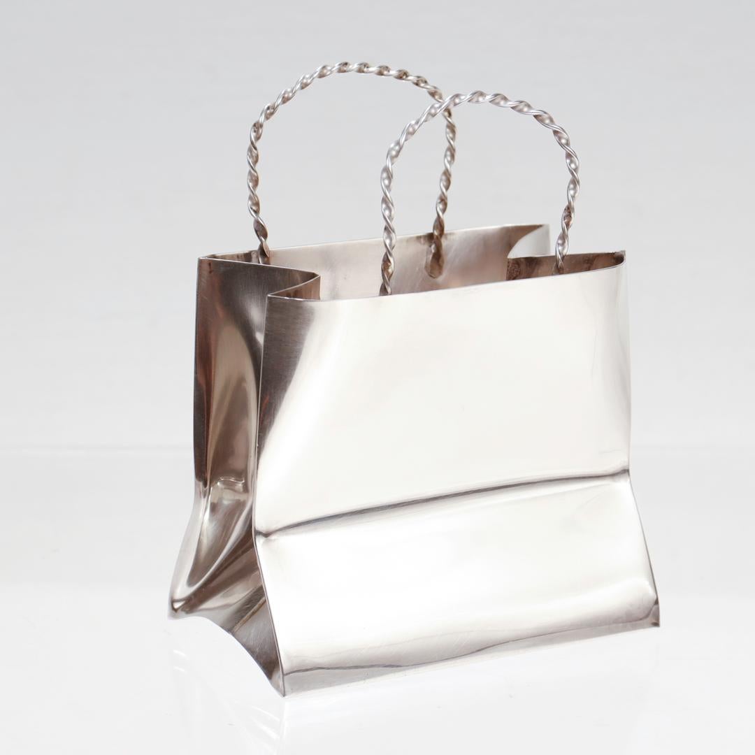 A fine vintage miniature shopping or gift bag.

By Cartier.

In sterling silver.

With slightly 'crumpled' sides and braided handles

Simply wonderful, whimsical Cartier!

Date:
Mid to Late 20th Century

Overall Condition:
It is in overall good,