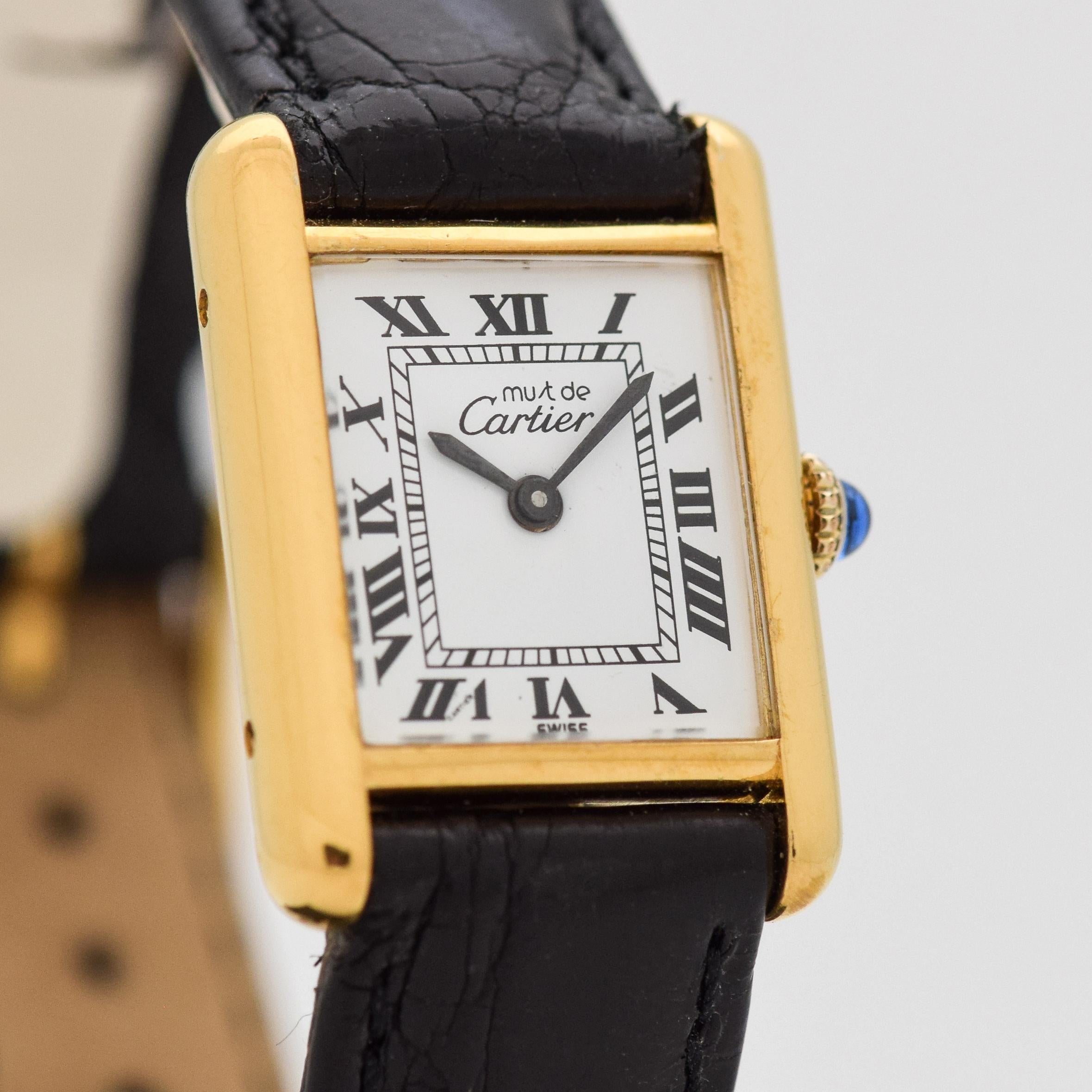 1980's Vintage Cartier Ladies Classic Size Must de Tank 18k Yellow Gold Plated Over Sterling Silver watch with Original White Dial with Black Roman Numerals. 20mm x 27mm lug to lug (0.79 in. x 1.06 in.) - 17 jewel, manual caliber ETA movement.