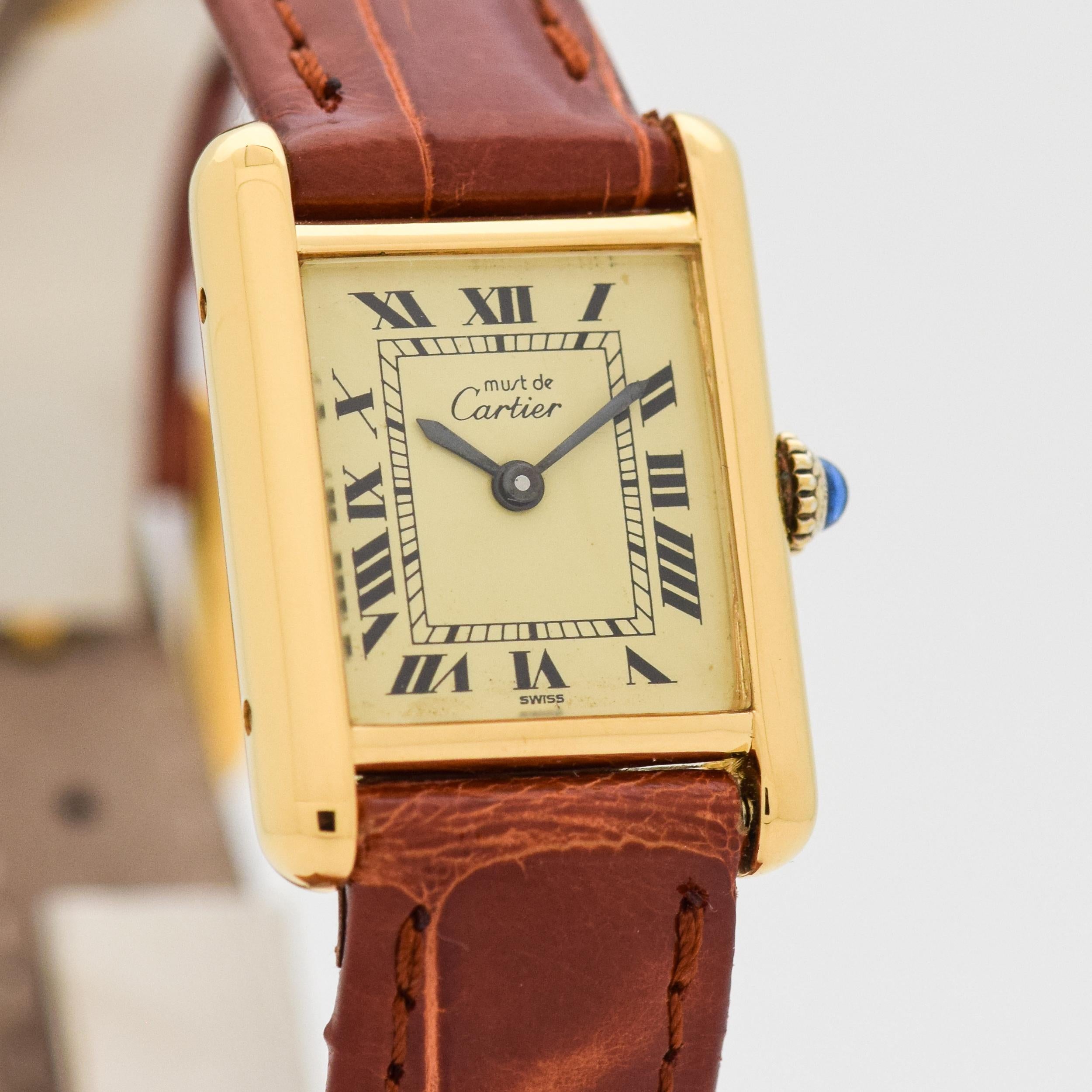 1980's Vintage Cartier Ladies Classic Size Must de Tank 18k Yellow Gold Plated Over Sterling Silver watch with Original Gold/Champagne Dial with Black Roman Numerals. 20mm x 27mm lug to lug (0.79 in. x 1.06 in.) - 17 jewel, manual caliber ETA