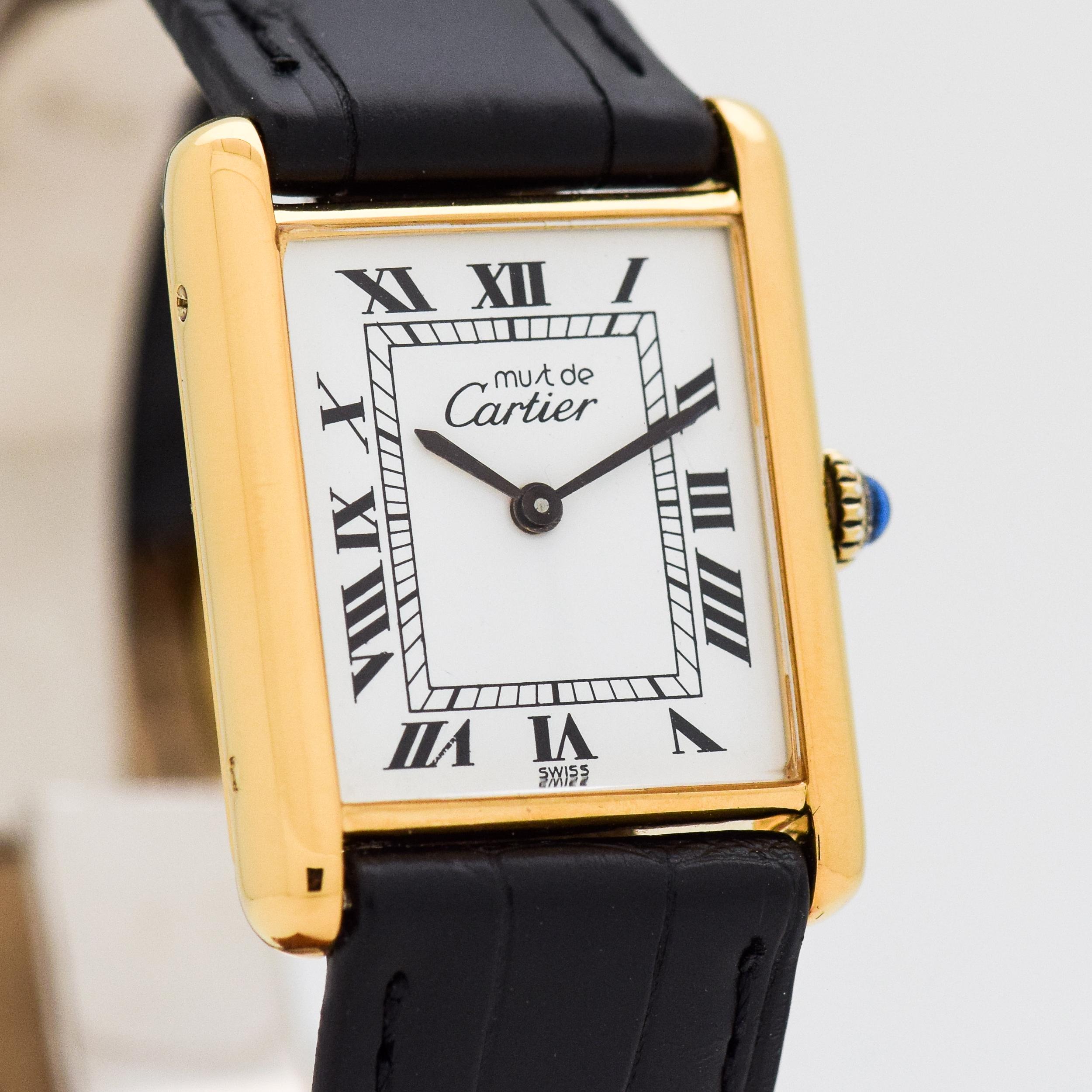 1980's Vintage Cartier Men's Classic Size Must de Tank 18k Yellow Gold Plated Over Sterling Silver watch with Original White Dial with Black Roman Numerals. 23mm x 30mm lug to lug (0.91 in. x 1.18 in.) - 17 jewel, manual caliber ETA movement.