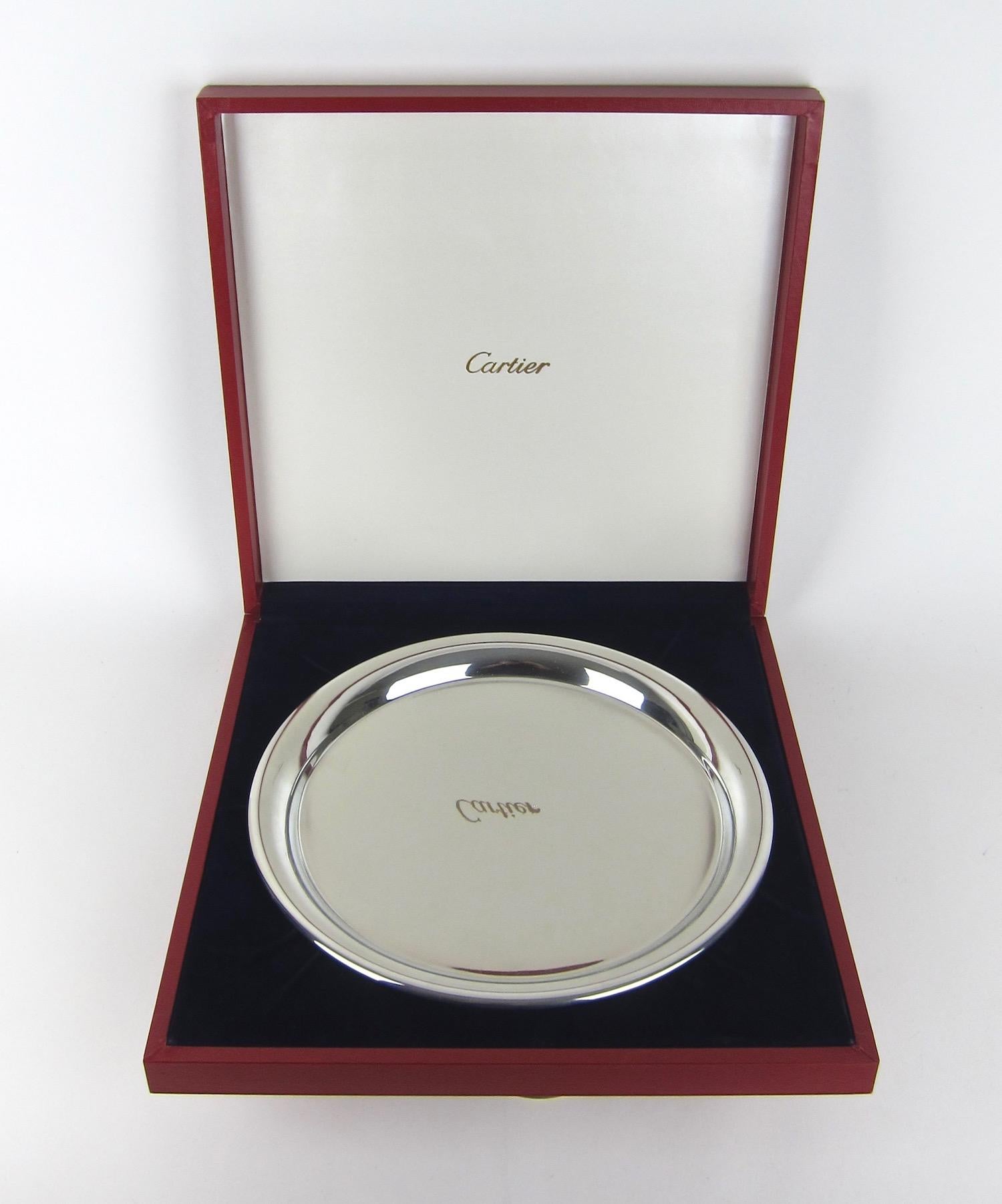 A vintage Cartier silver metal serving tray of highly polished and reflective pewter, made in France, circa 1977. The round tray has a sleek Minimalist design with a wire-wrapped rim and is stamped 
