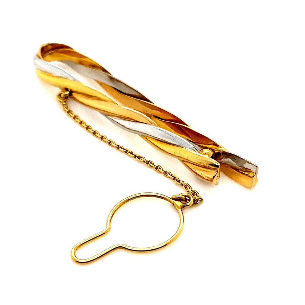 A vintage Cartier tri-gold tie clip, Circa 1960.

This elegant and unusual tie clip by Cartier features interwoven lines of plain polished 18 karat yellow, white and rose gold. 

The clip has a flexible opening which is easy to access and can