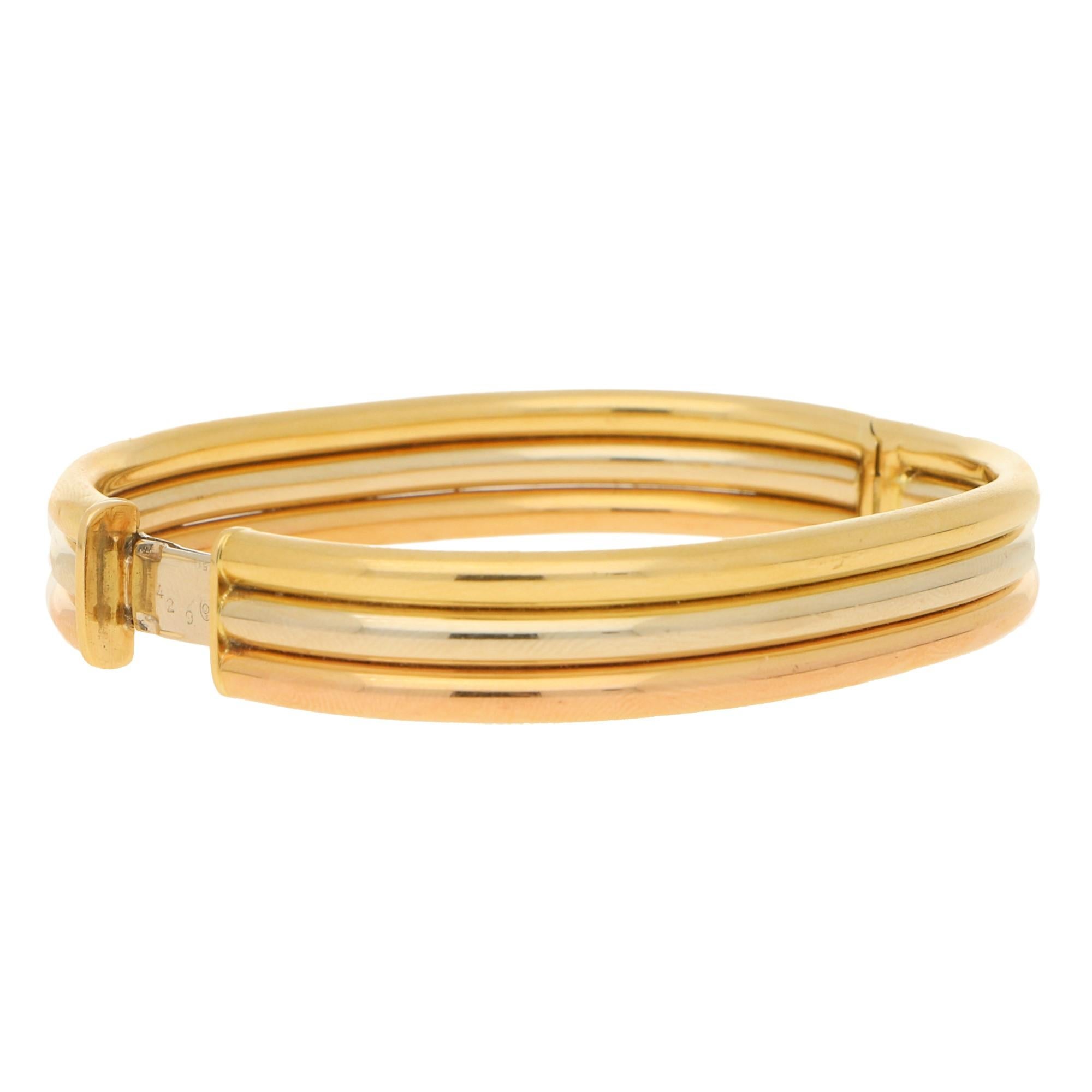 A classic vintage Cartier trinity bangle crafted in 18k yellow, rose and white gold. Because the bracelet is designed to be solid instead of the typical trinity design, once on, we see these lovely grooves in the bracelet which has a beautiful