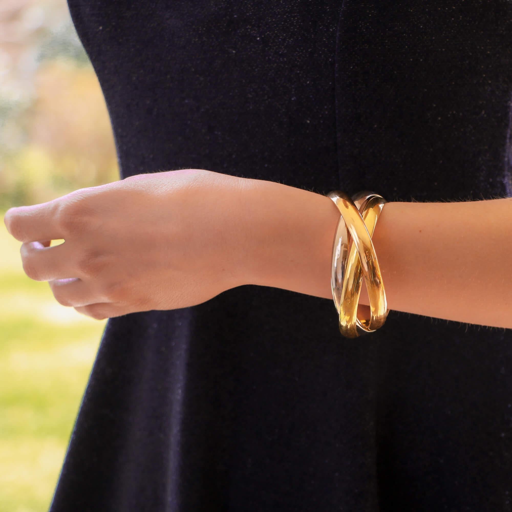 A classic vintage Cartier Trinity bangle set in 18k yellow, rose and white gold, circa 2000.

The bracelet is composed of three interlinked 8.5-millimetre bangles that are designed to roll with ease on the wrist. The trinity bangles come in three