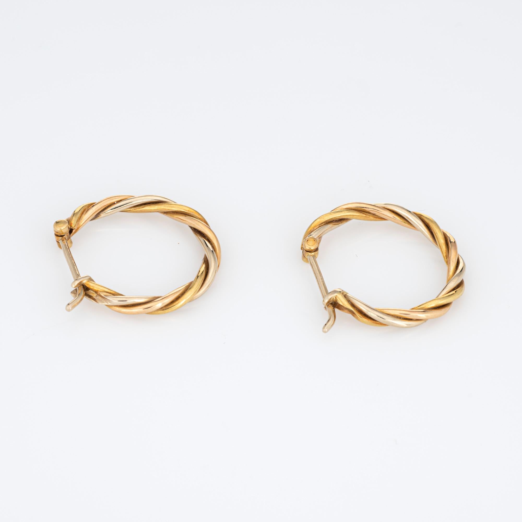 Out of production vintage Cartier 'Trinity' earrings crafted in 18k yellow, rose and white gold (circa 1990s).  

The polished gold Cartier earrings measure 3/4 inch in length and are designed as a smaller hoop. The earrings are fitted with posts to