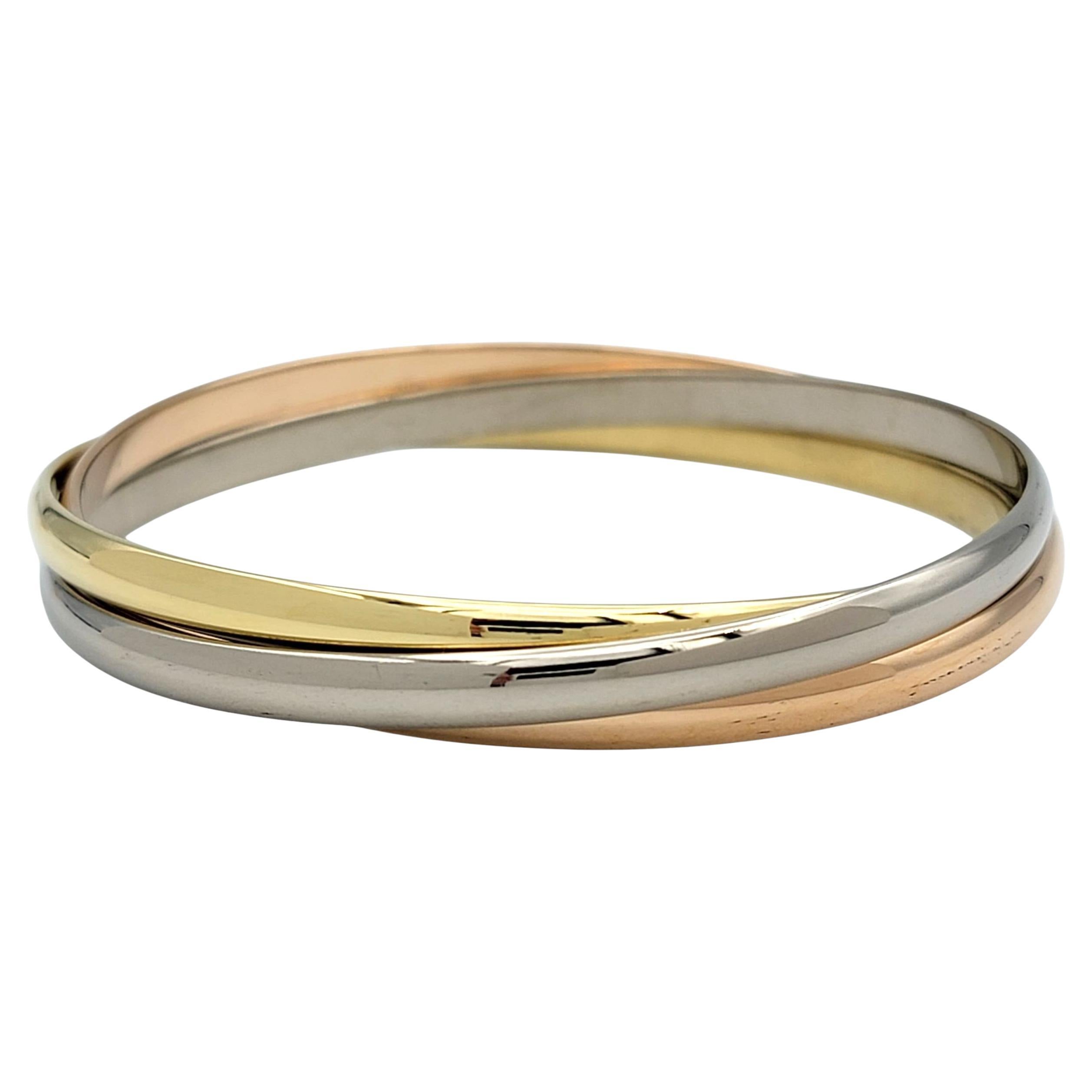 Dieses Vintage-Armband von Cartier Trinity ist ein zeitloses Symbol für Eleganz und französisches Design. Das aus ineinandergreifenden Bändern aus 18 Karat Gelb-, Weiß- und Roségold gefertigte Armband steht für Liebe, Treue und Freundschaft. Die