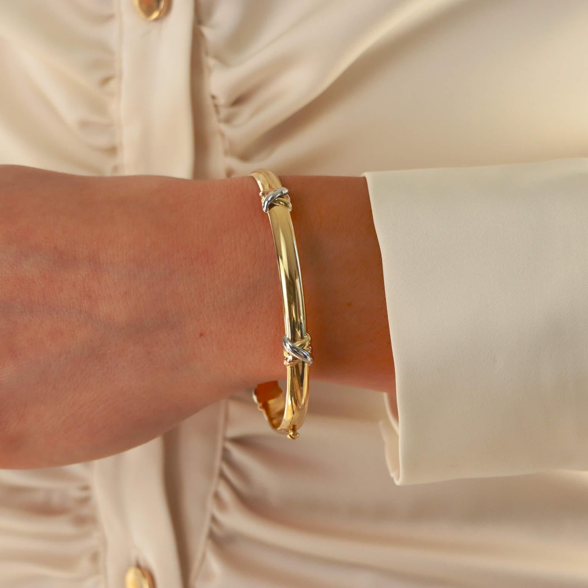 A unique Cartier ‘Trinity Kiss’ screw bangle set in 18k yellow, rose and white gold.

Baring resemblance to the iconic Cartier Love bangle, this piece shares inspiration. The bangle is composed of a solid 5.5 millimetre yellow gold bangle set with