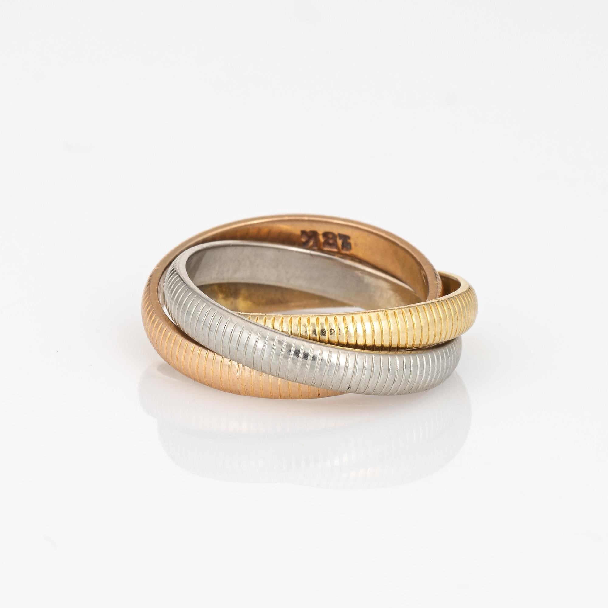 Out of production vintage Cartier Trinity ring crafted in 18k yellow, white & rose gold (circa 1960s to 1970s).  

The Cartier ring features ribbed bands of 18k rose, yellow & white gold. Each band measures 3mm wide. The ring is great worn alone or