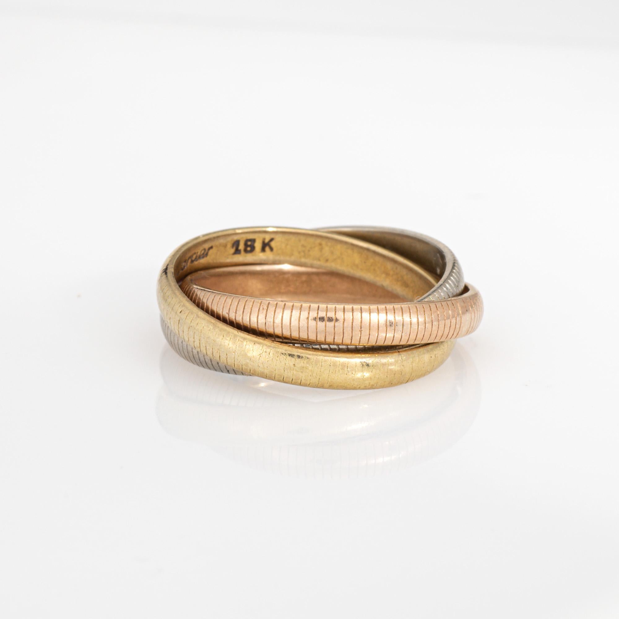 Anello vintage fuori produzione Cartier Trinity in oro giallo, bianco e rosa 18 carati (circa anni '70).  

L'anello Cartier presenta fasce a coste in oro rosa, giallo e bianco a 18 carati. Ogni fascia misura 2,5 mm di larghezza. L'anello è perfetto