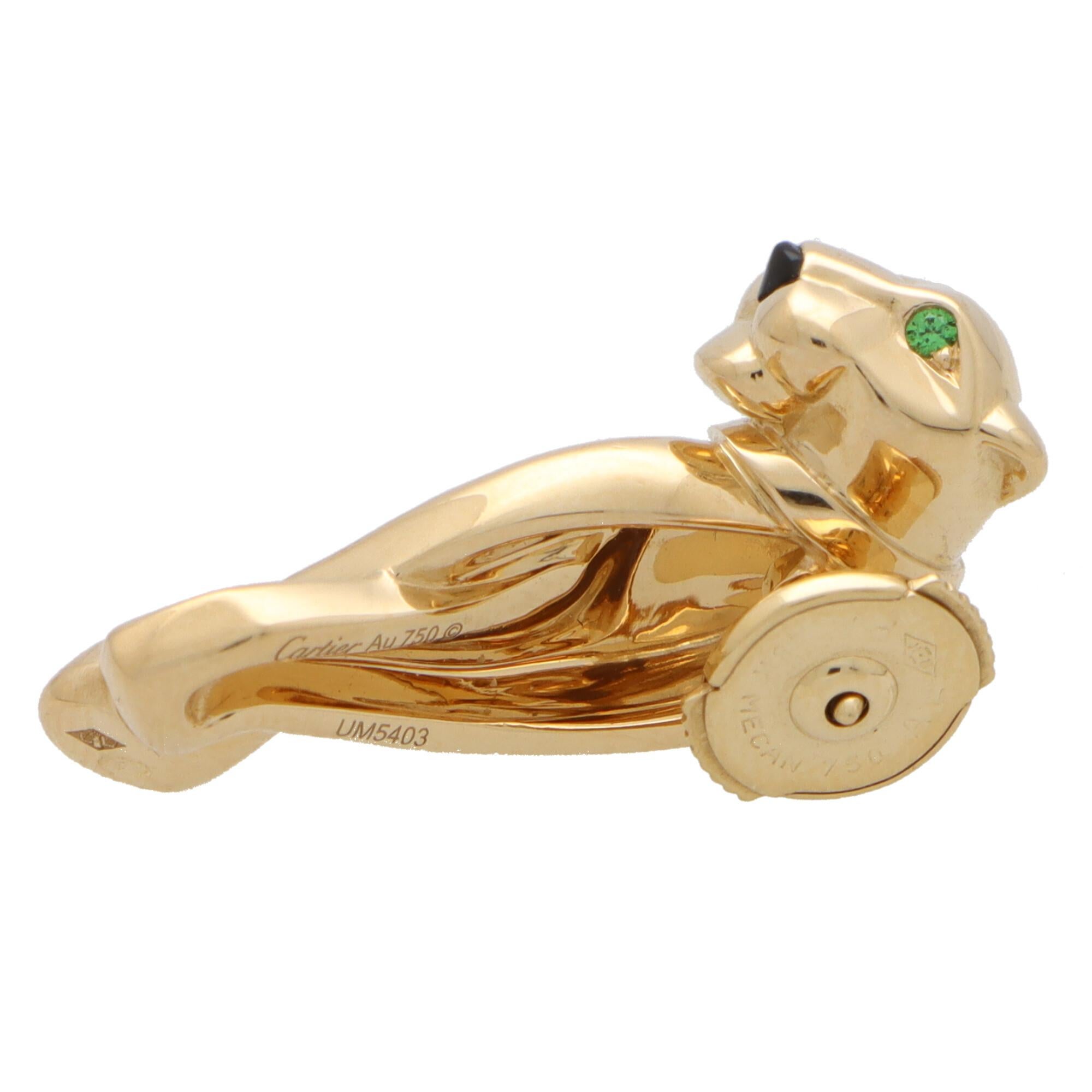 A rare vintage Cartier panther pin brooch set in 18k yellow gold.

This beautiful piece depicts Cartier’s iconic panther motif and is made of solid 18k yellow gold. The panther face is set with two round cut tsavorite garnet eyes and a onyx nose and